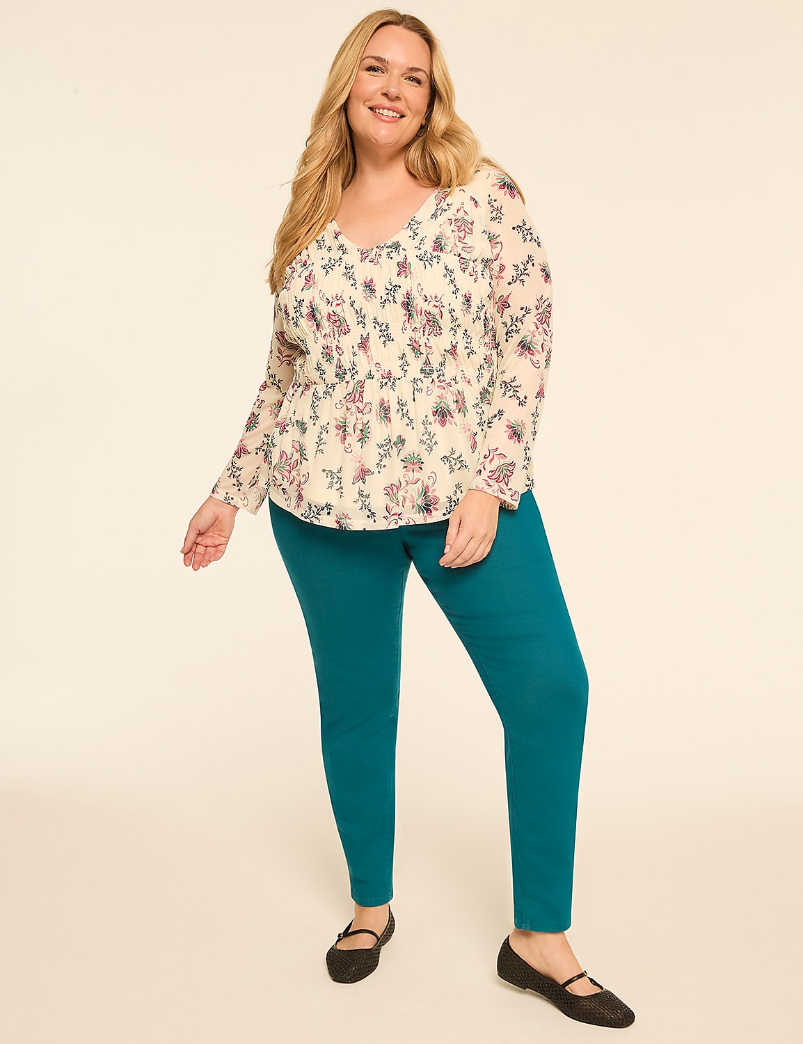 A smiling woman in a floral blouse and teal leggings stands against a plain, light-colored background. Product Image 3