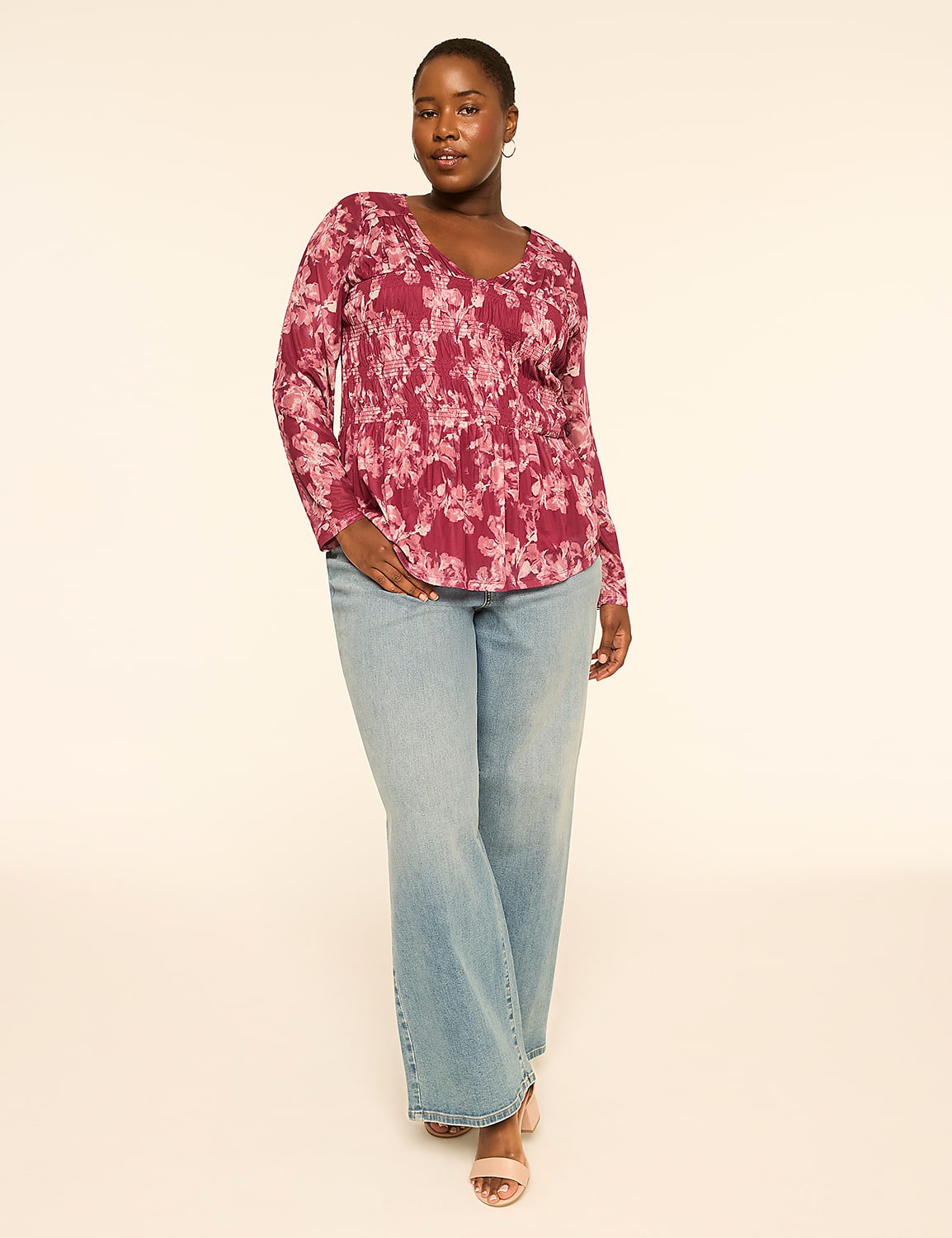 A woman in a floral top and light wash jeans stands against a plain, light-colored background. Product Image 3