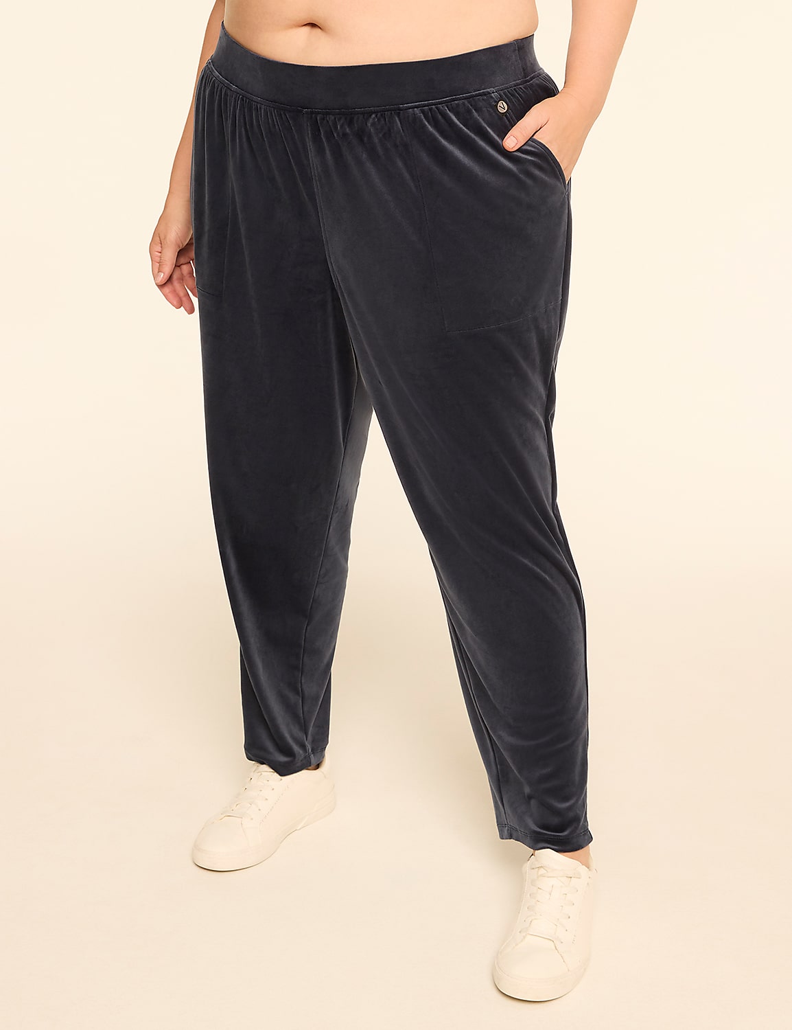 A person wearing dark blue velvet pants and white sneakers stands against a plain, light-colored background. Product Image 1