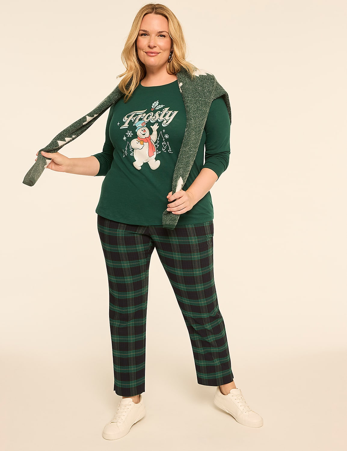 A woman in a green "Frosty" t-shirt and plaid pants stands against a plain, light-colored background. Product Image 3