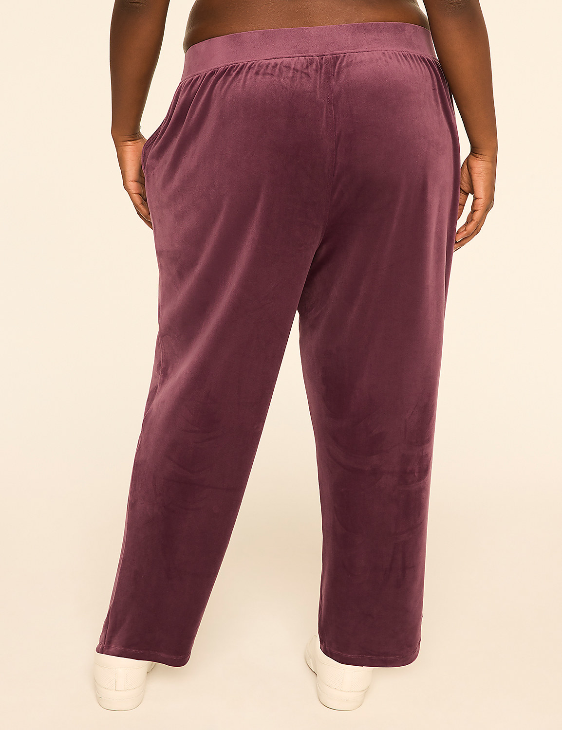 A person wearing plum-colored velvet pants stands against a plain, light-colored background. Product Image 2