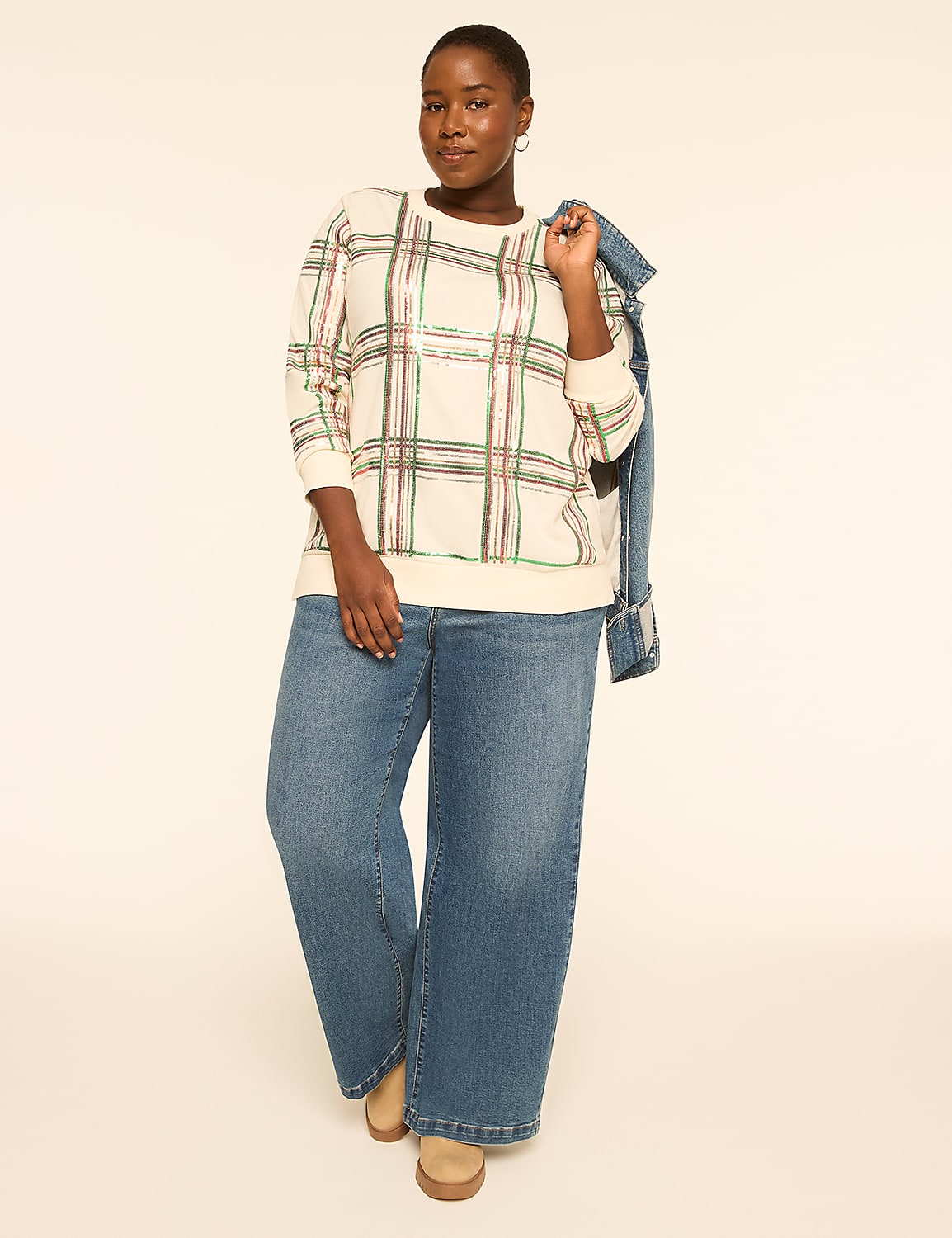 A woman in a plaid sweater and wide-leg jeans stands against a plain, light-colored background with a denim jacket draped over her shoulder. Product Image 3