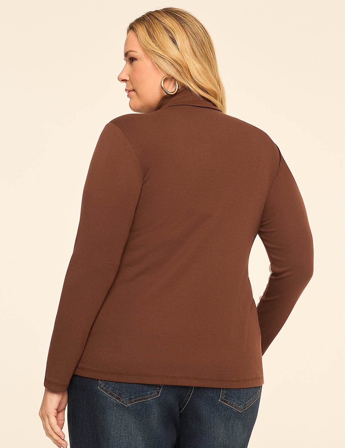 A woman in a brown turtleneck and blue jeans stands against a plain, light-colored background. Product Image 2