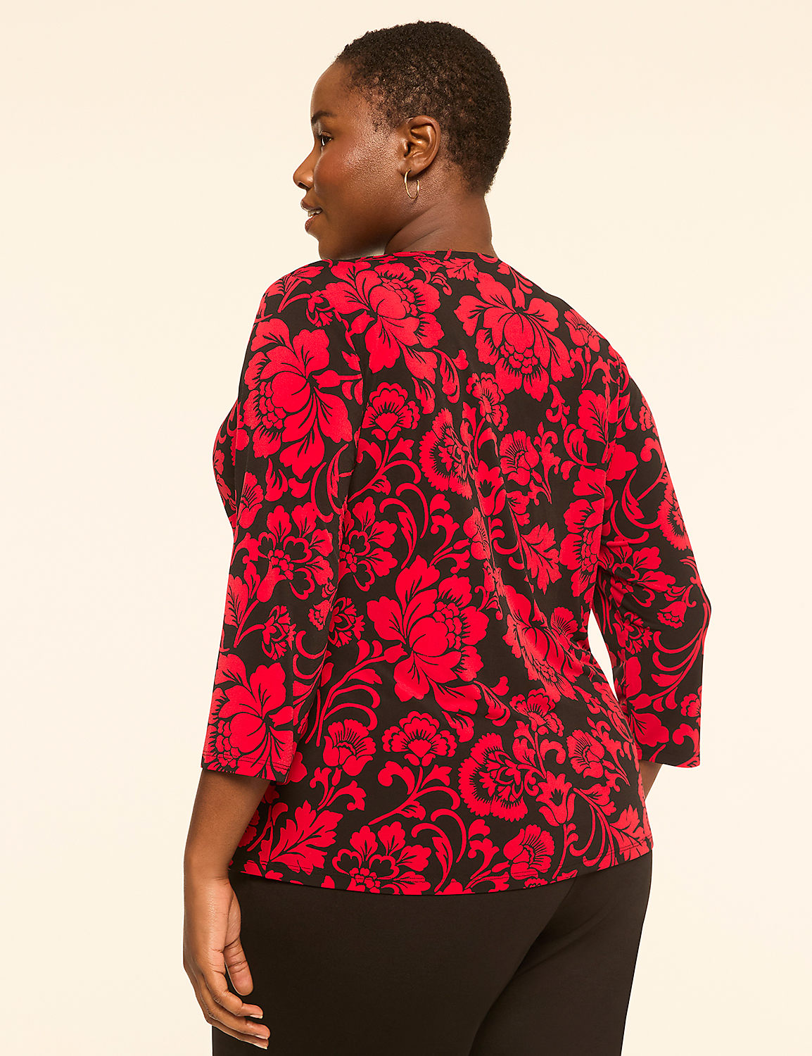 A woman in a red and black floral top stands against a plain, light-colored background. Product Image 2