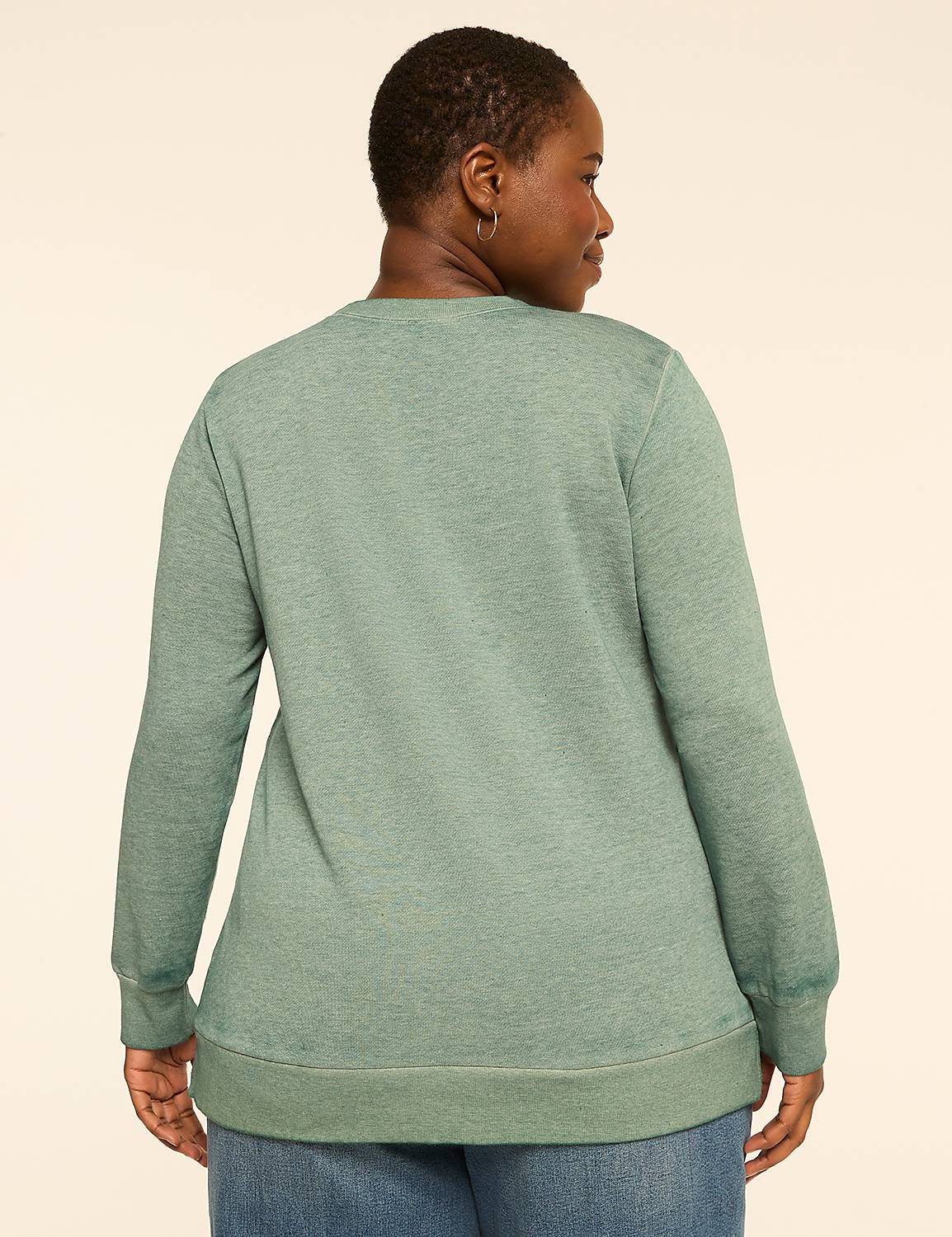 A woman in a green sweatshirt stands against a plain, light-colored background. Product Image 2