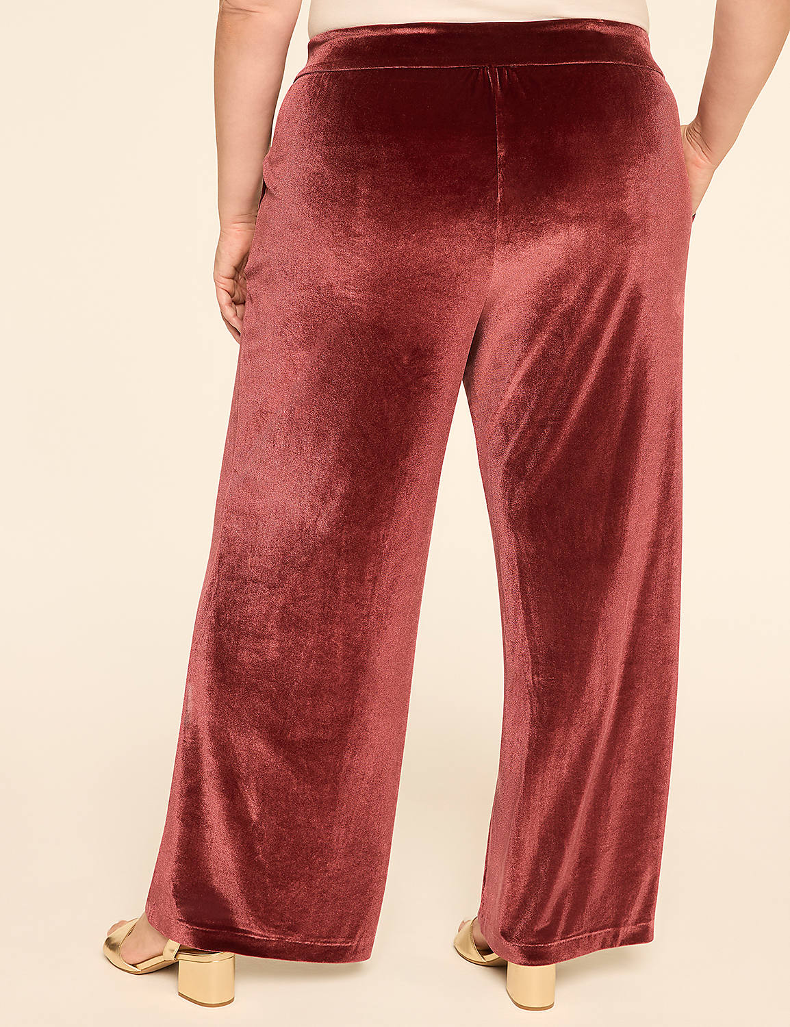A person wearing rust-colored velvet palazzo pants stands against a plain, light-colored background. Product Image 2
