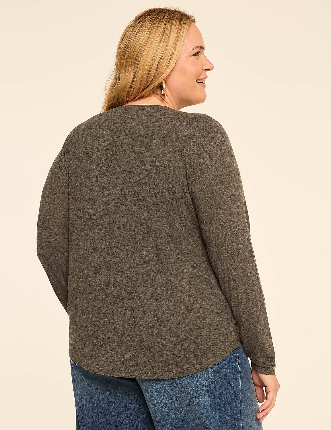 A woman in a gray long-sleeved shirt and blue jeans stands against a plain, light-colored background. Product Image 2