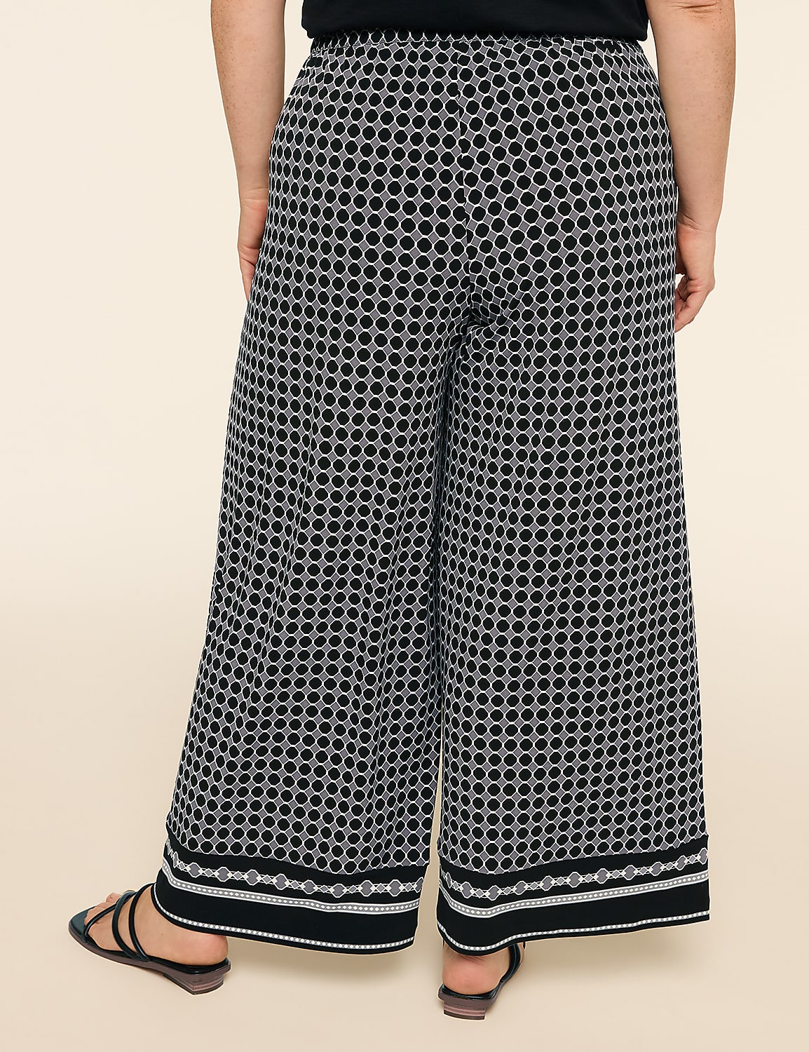 A person stands in wide-leg patterned pants with a plain background. Product Image 2