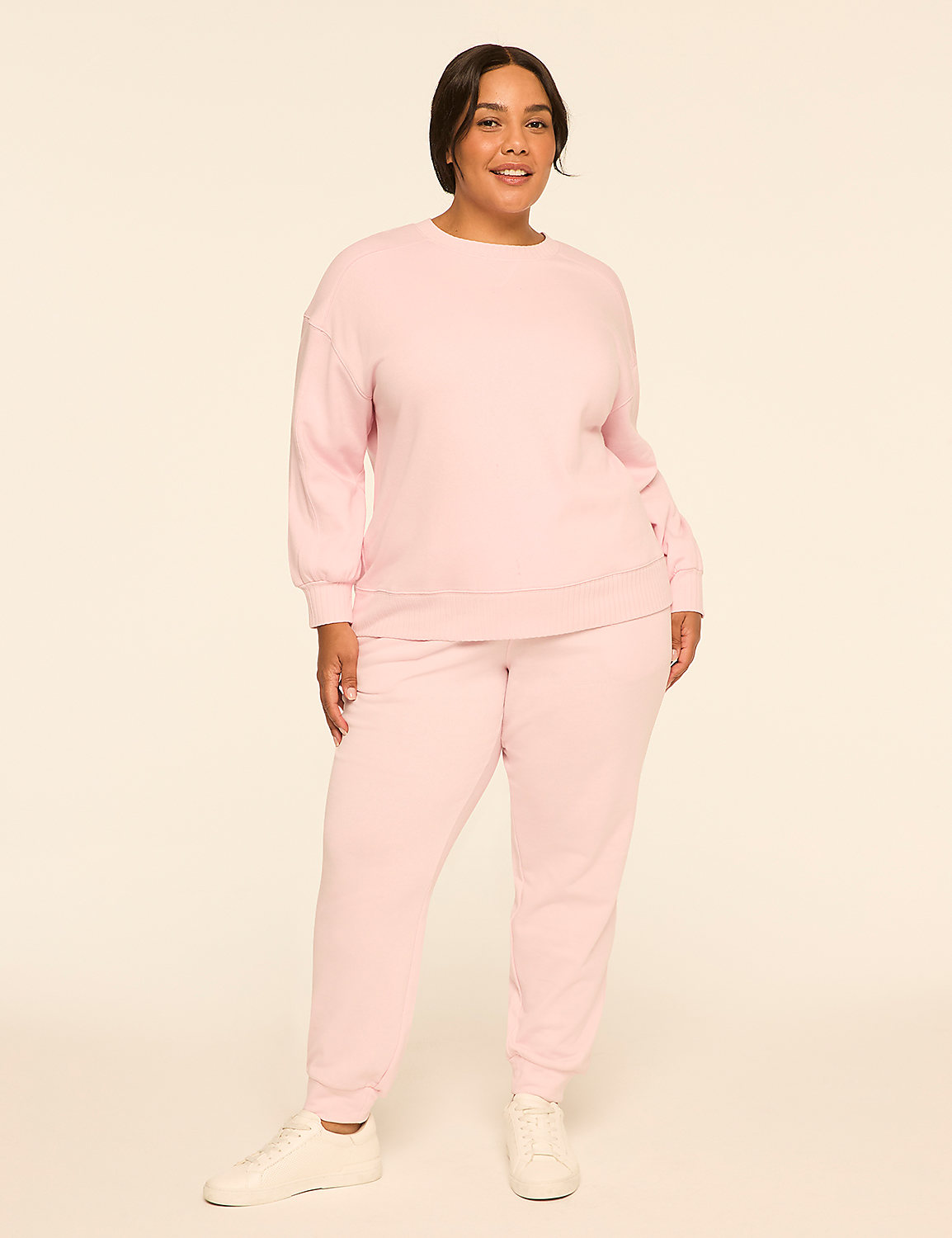 A smiling woman in a pink tracksuit stands against a plain, light-colored background. Product Image 3