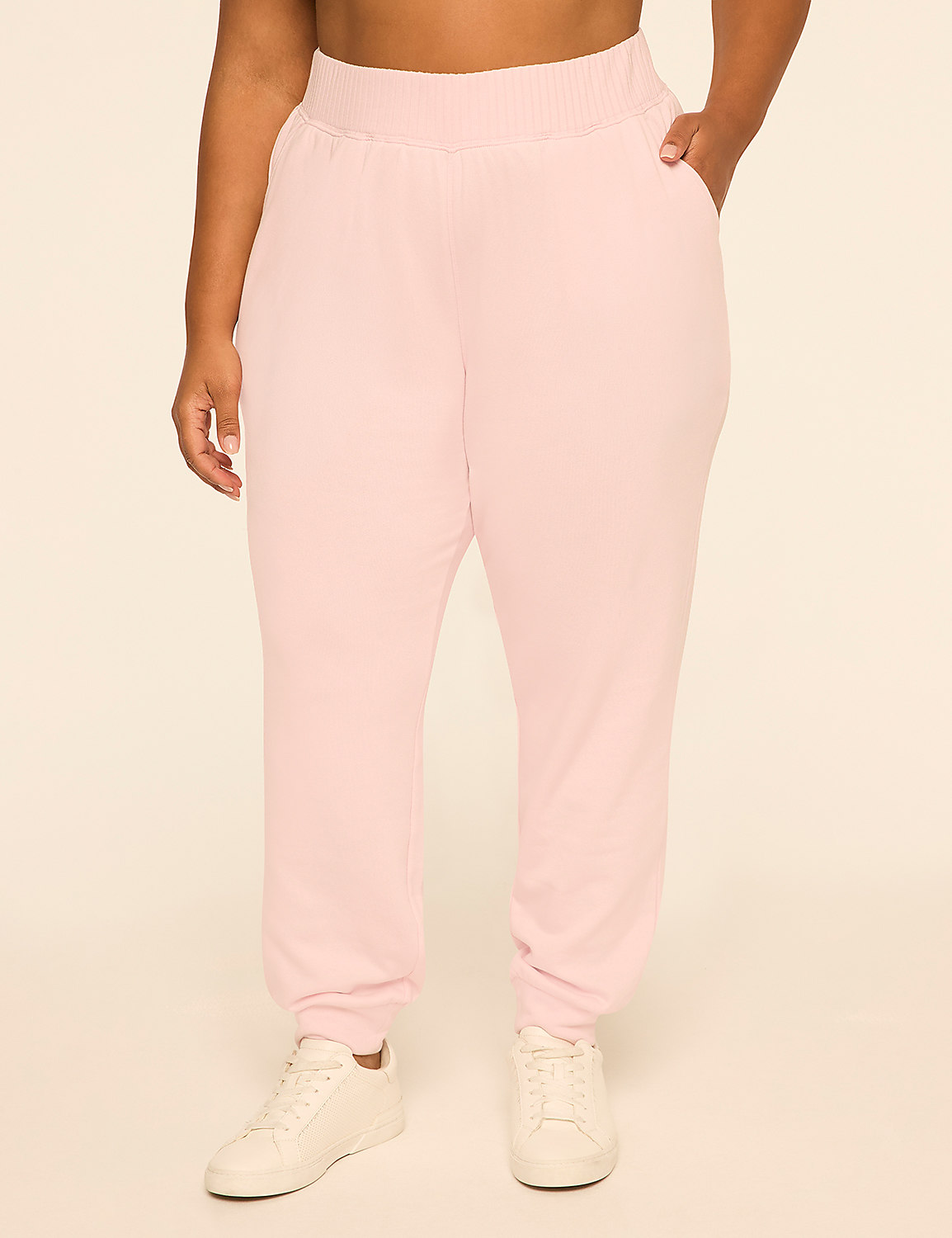 A person wearing light pink sweatpants and white sneakers stands against a plain, light-colored background. Product Image 1