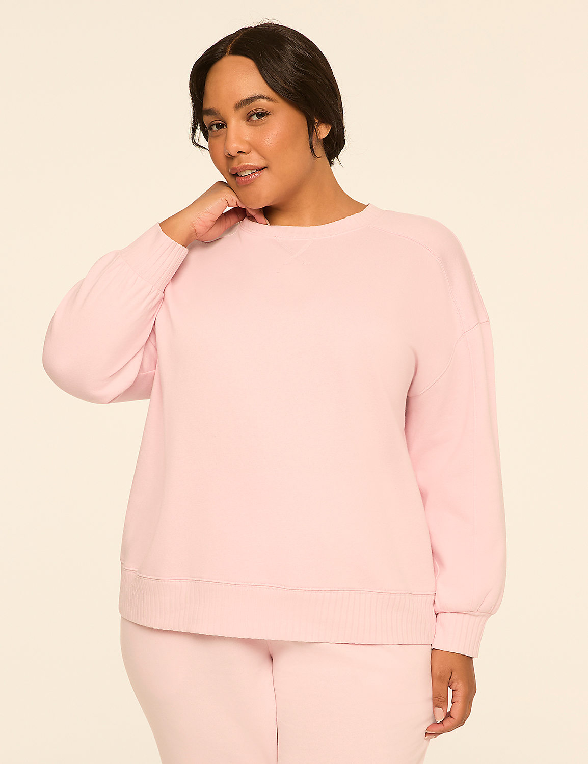 A woman in a pink sweatshirt and pants stands against a plain, light-colored background. Product Image 1