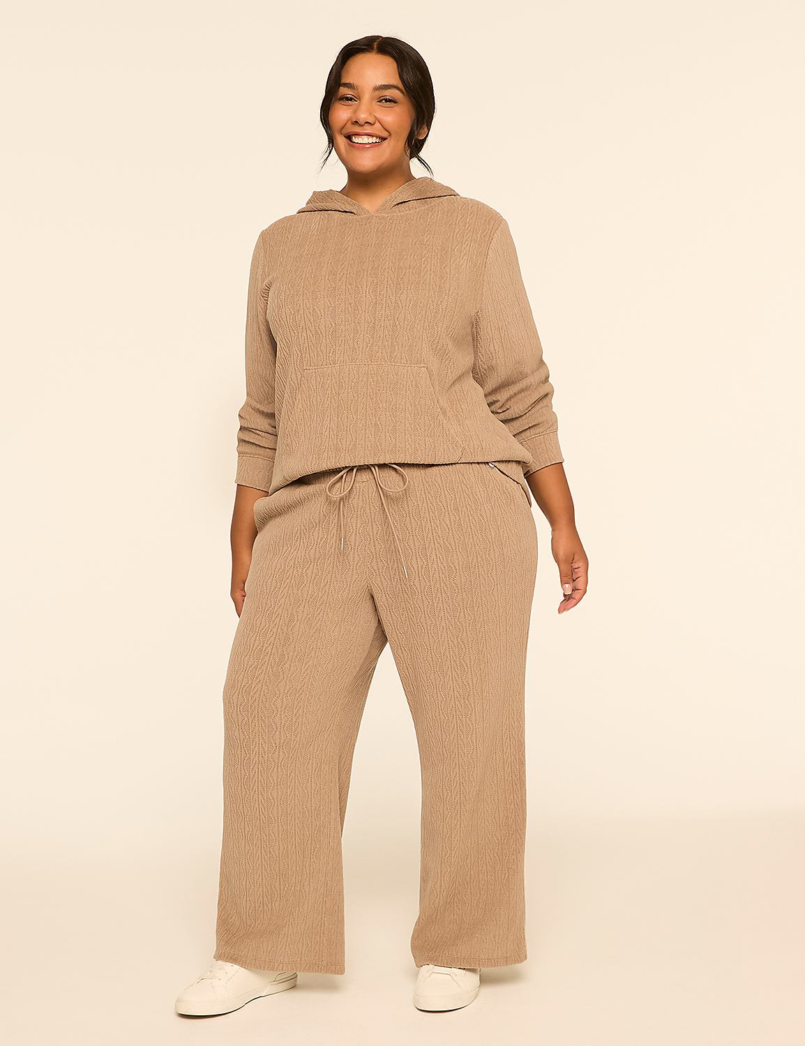 A smiling woman in a tan loungewear set stands against a plain, light-colored background. Product Image 3