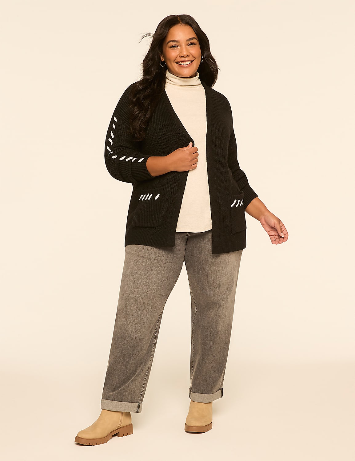 A smiling woman in a black cardigan and gray jeans stands against a plain, light-colored background. Product Image 3