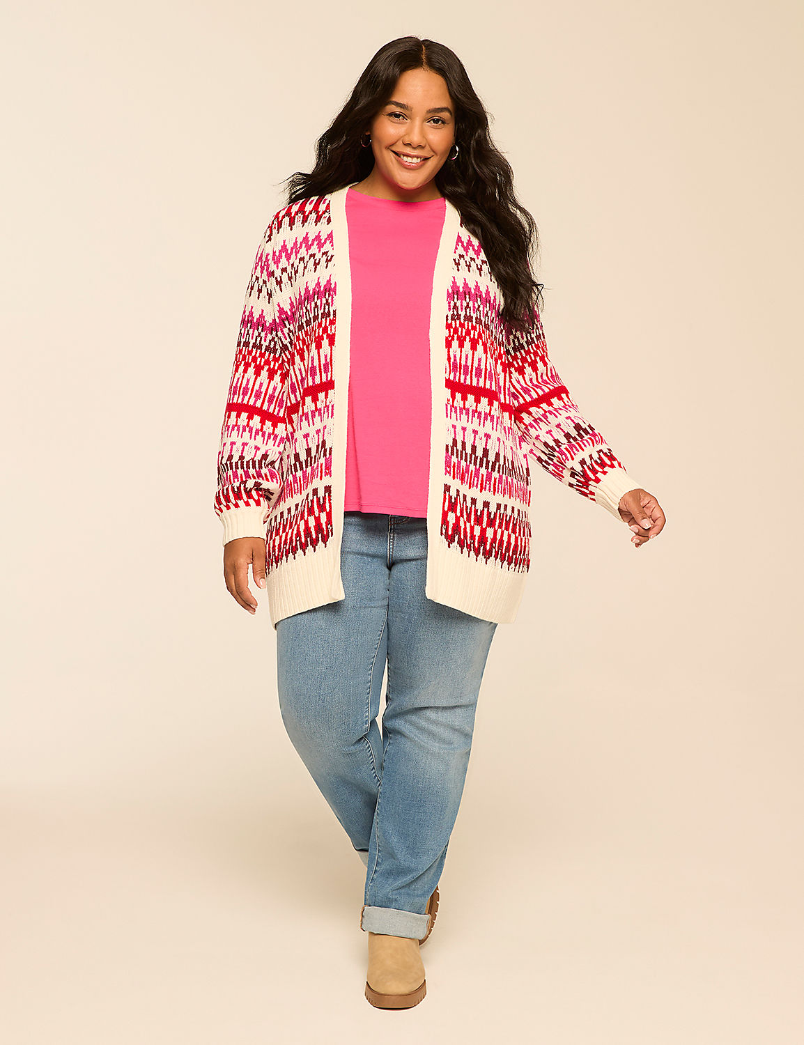 A smiling woman in a pink top, light blue jeans, and a colorful cardigan stands against a plain, light-colored background. Product Image 3
