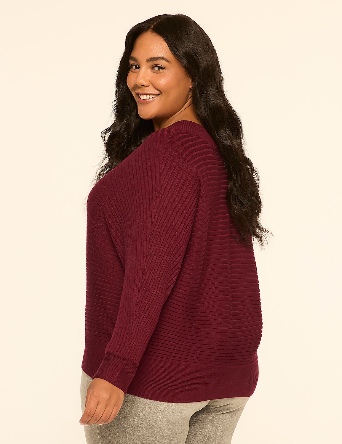 A woman in a maroon sweater and gray pants smiles over her shoulder against a plain, light-colored background. Product Image 2
