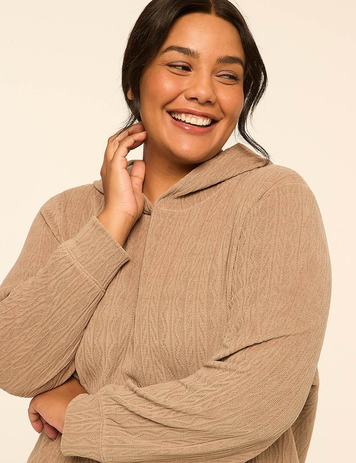 A smiling woman in a textured tan hoodie poses against a plain, light-colored background. Product Image 4