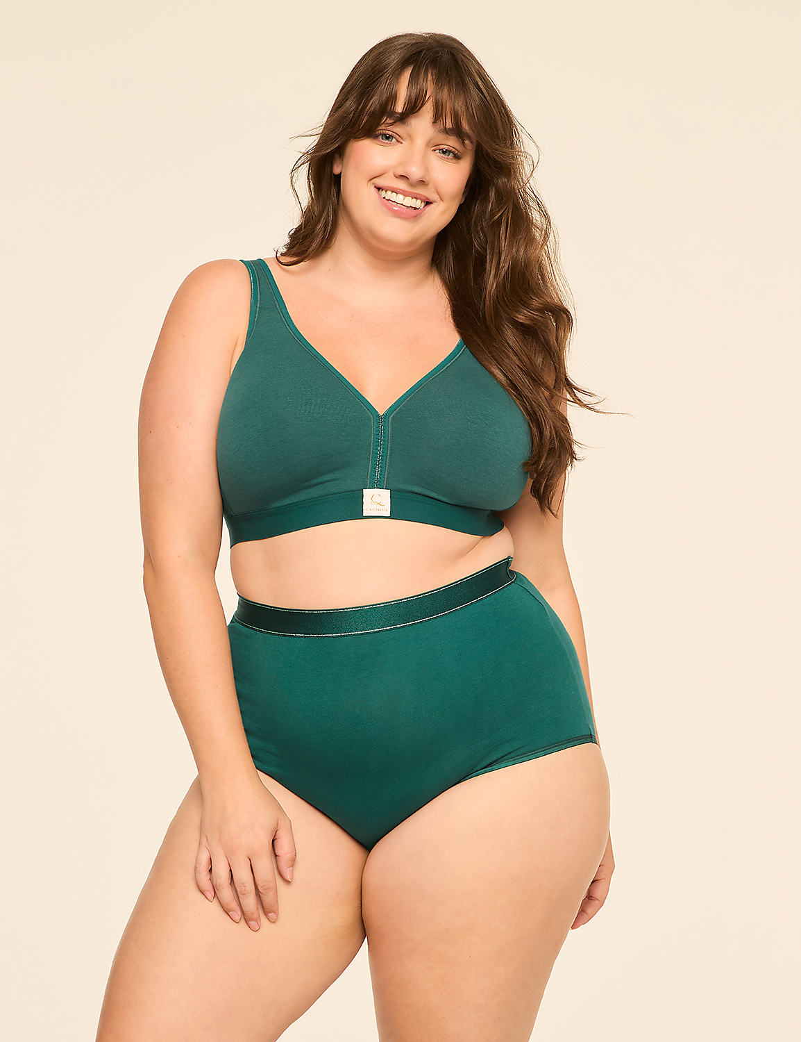 A smiling woman in a green bra and high-waisted underwear stands against a plain, light-colored background. Product Image 4