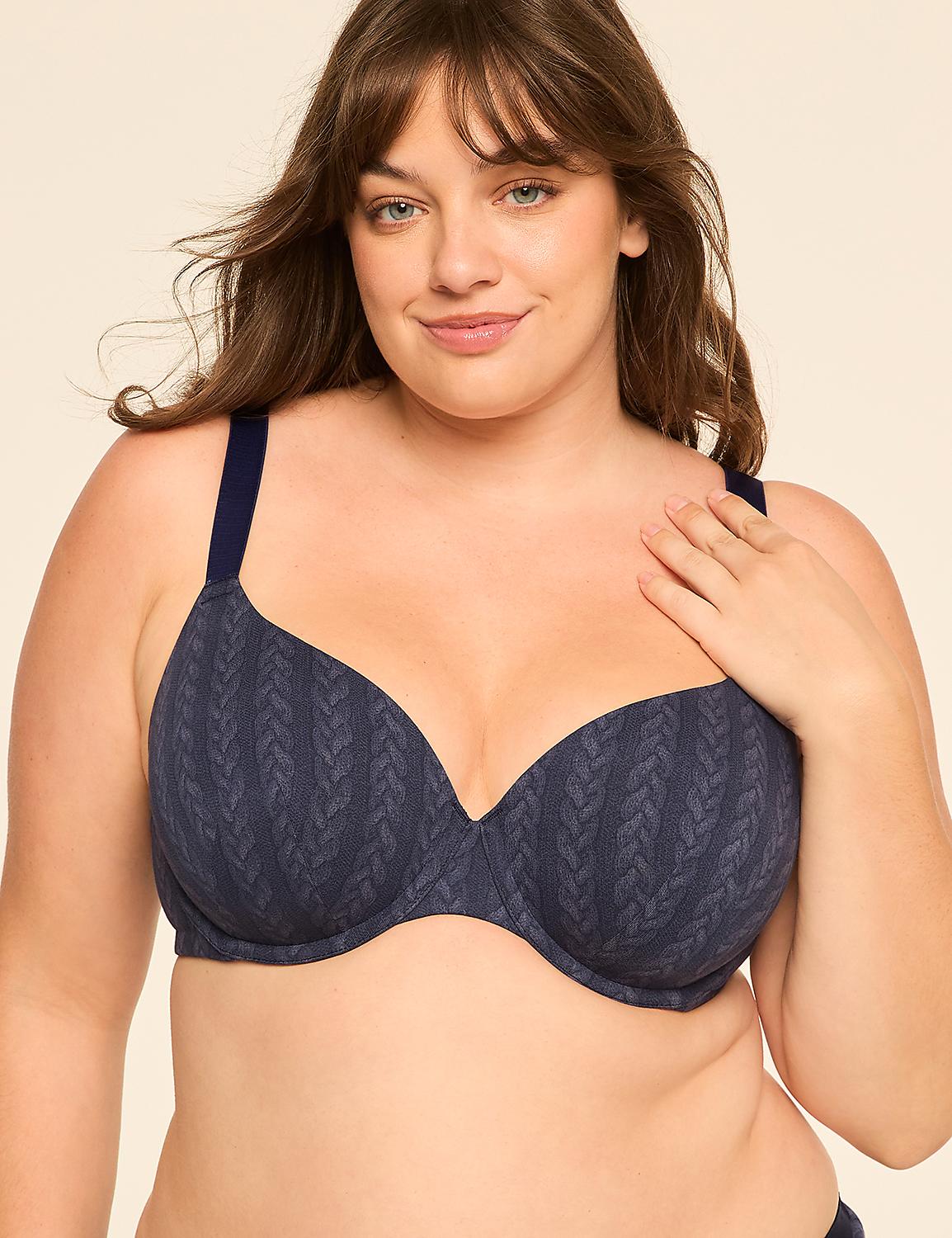 A woman with a hand on her chest wears a patterned blue bra against a plain, light-colored background. Product Image 1