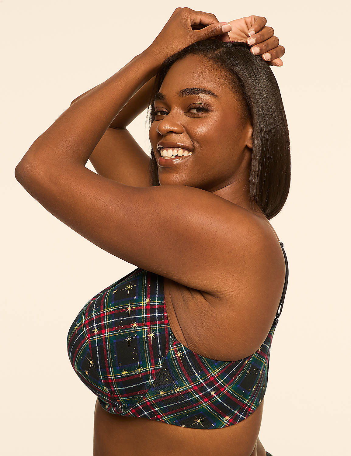 A smiling woman in a plaid bra poses with her arms behind her head against a plain, light-colored background. Product Image 3