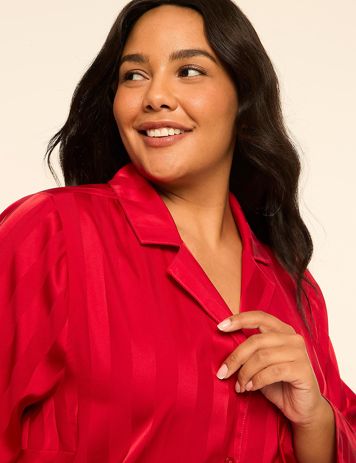 A smiling woman with dark hair wears a red satin pajama top in the foreground, against a plain, light-colored background. Product Image 4