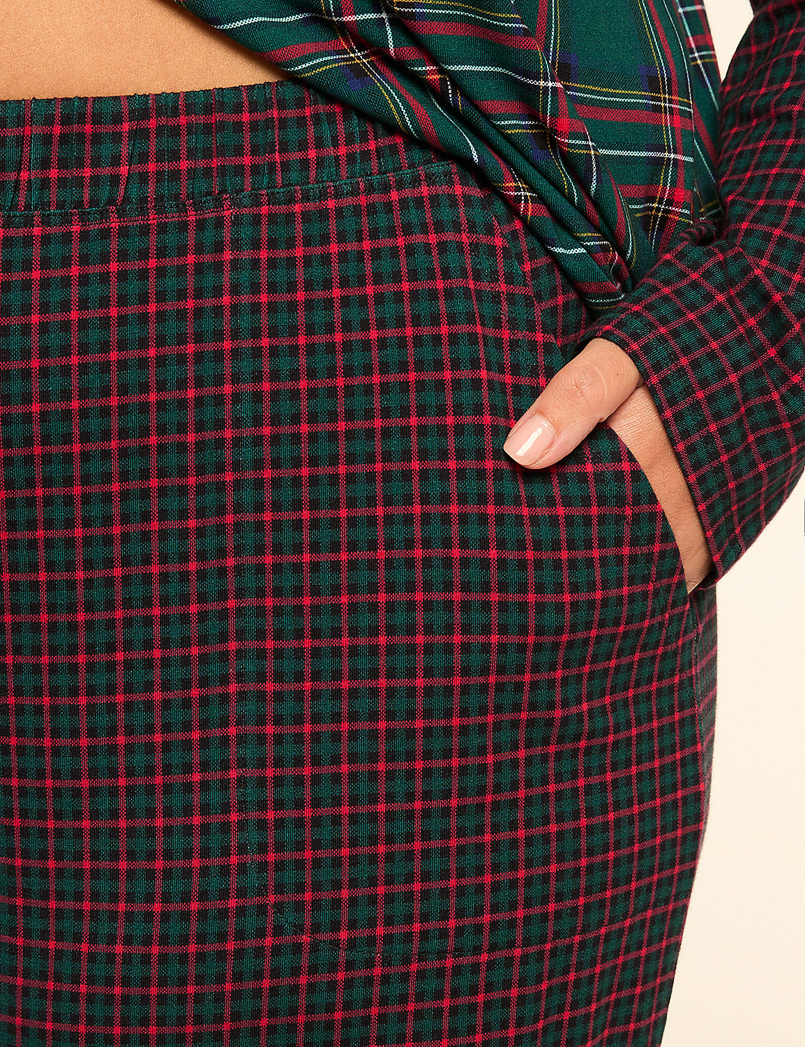 A hand rests in the pocket of red and green plaid pants, with a matching plaid shirt visible in the background. Product Image 3