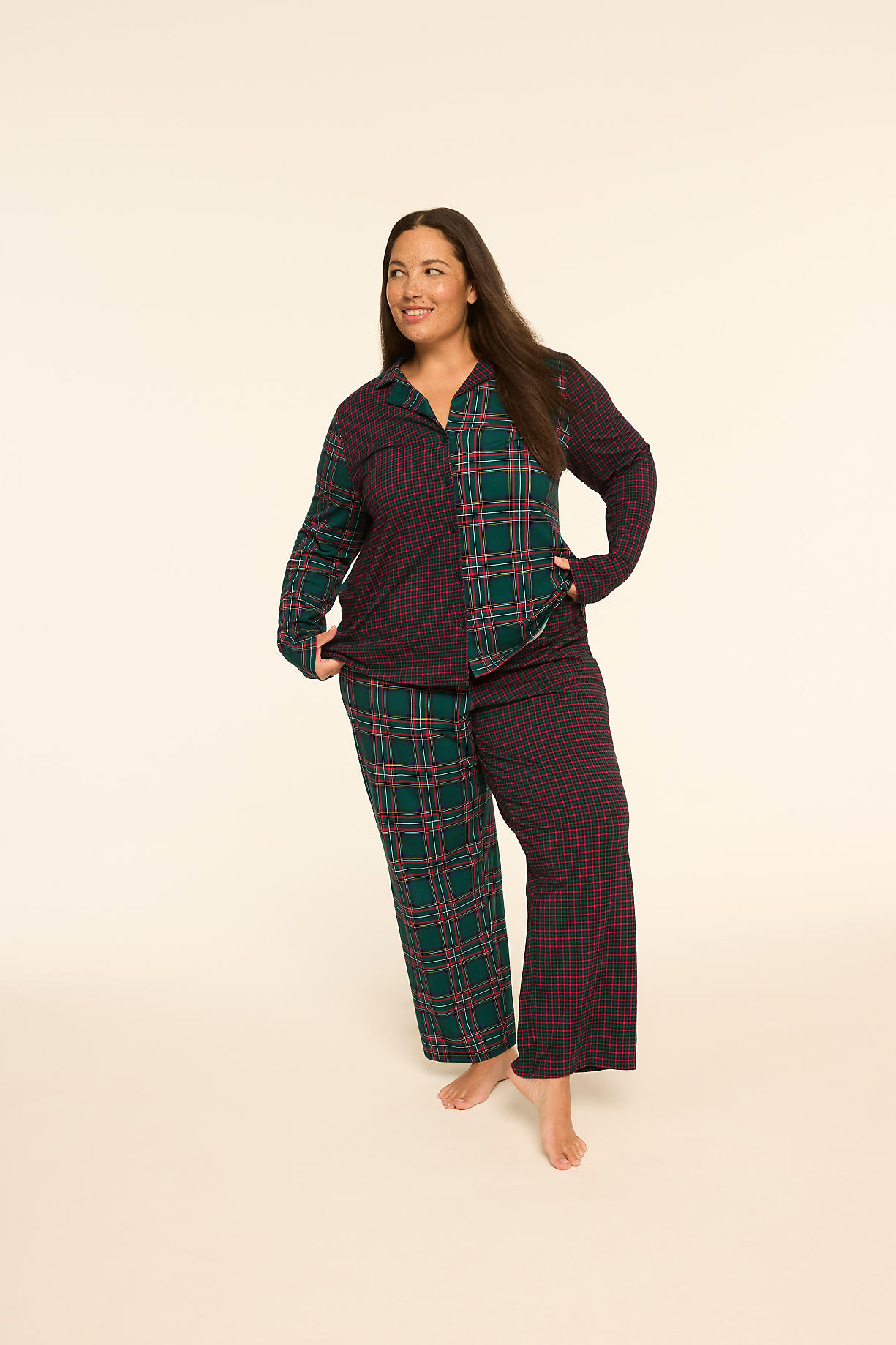 A woman stands in mismatched plaid pajamas against a plain, light-colored background. Product Image 5