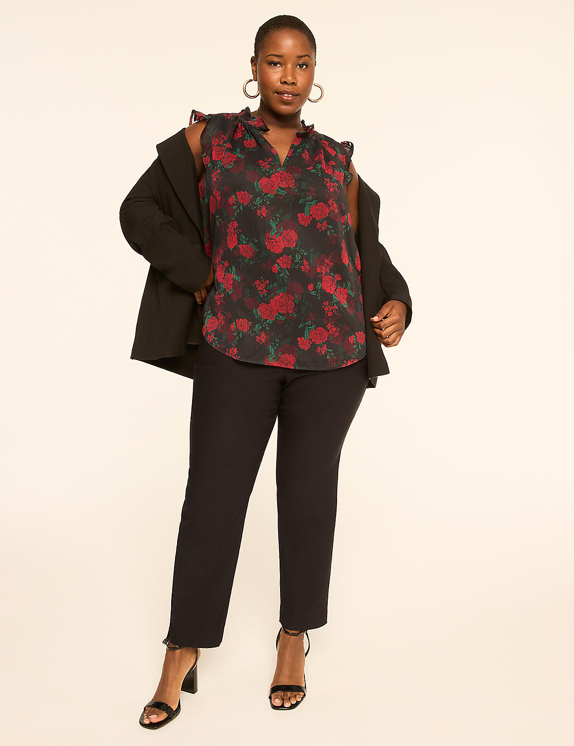 A woman in a floral top and black pants stands against a plain, light-colored background. Product Image 3