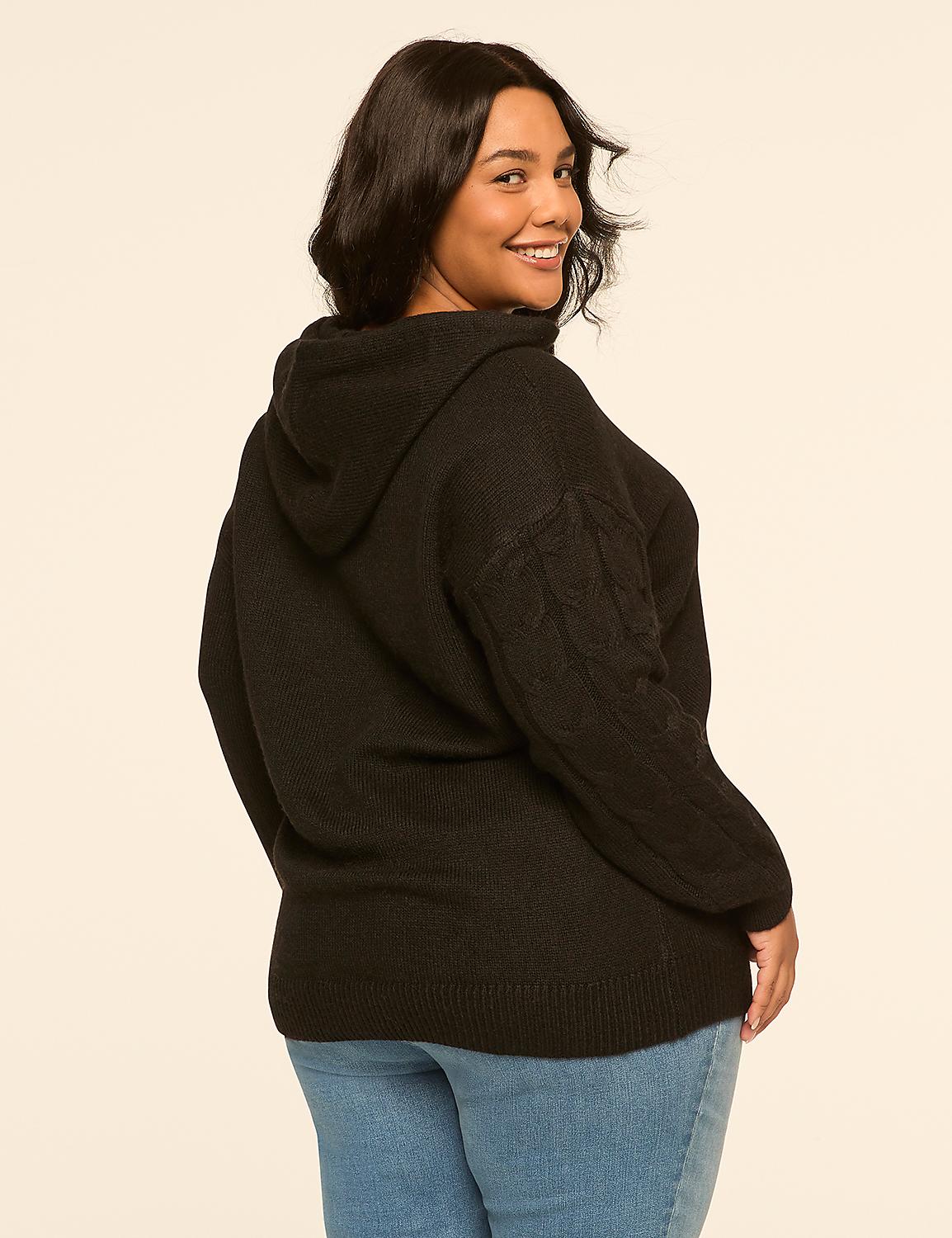 A woman in a black hooded sweater and blue jeans smiles over her shoulder against a plain, light-colored background. Product Image 2