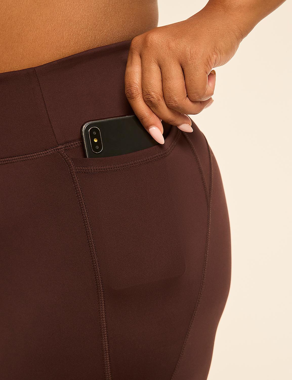 A hand tucks a smartphone into the pocket of dark brown leggings against a plain, light background. Product Image 4
