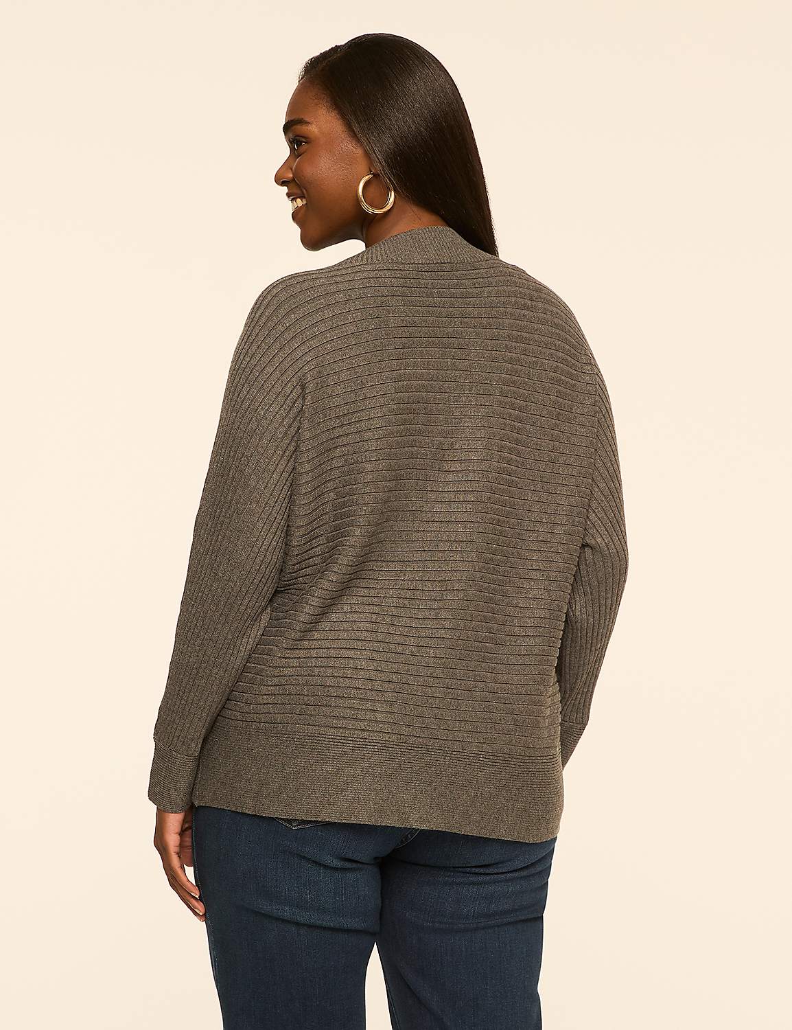 A woman in a gray cardigan and blue jeans stands against a plain, light brown background. Product Image 2
