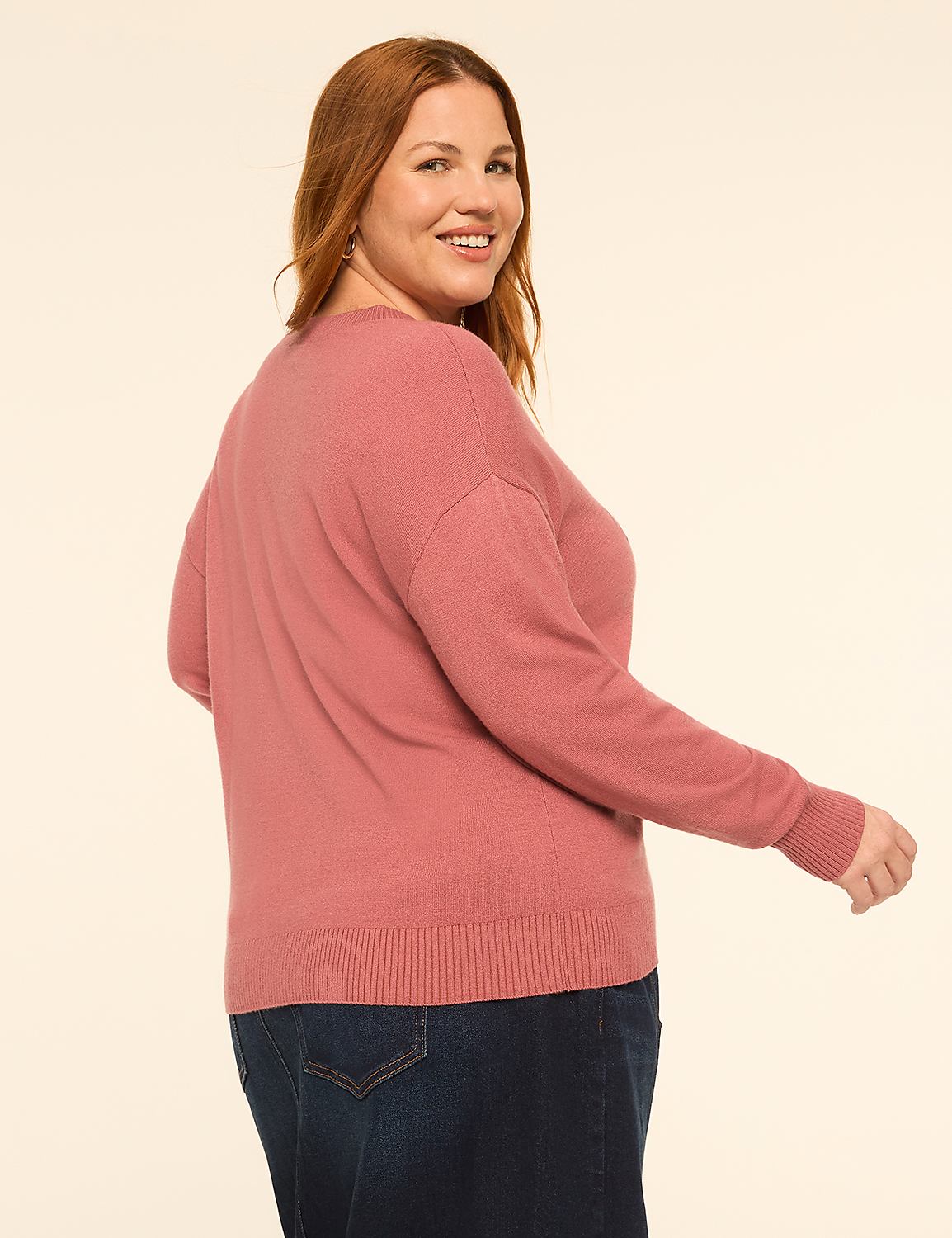 A woman in a pink sweater and dark skirt stands against a plain, light-colored background. Product Image 2