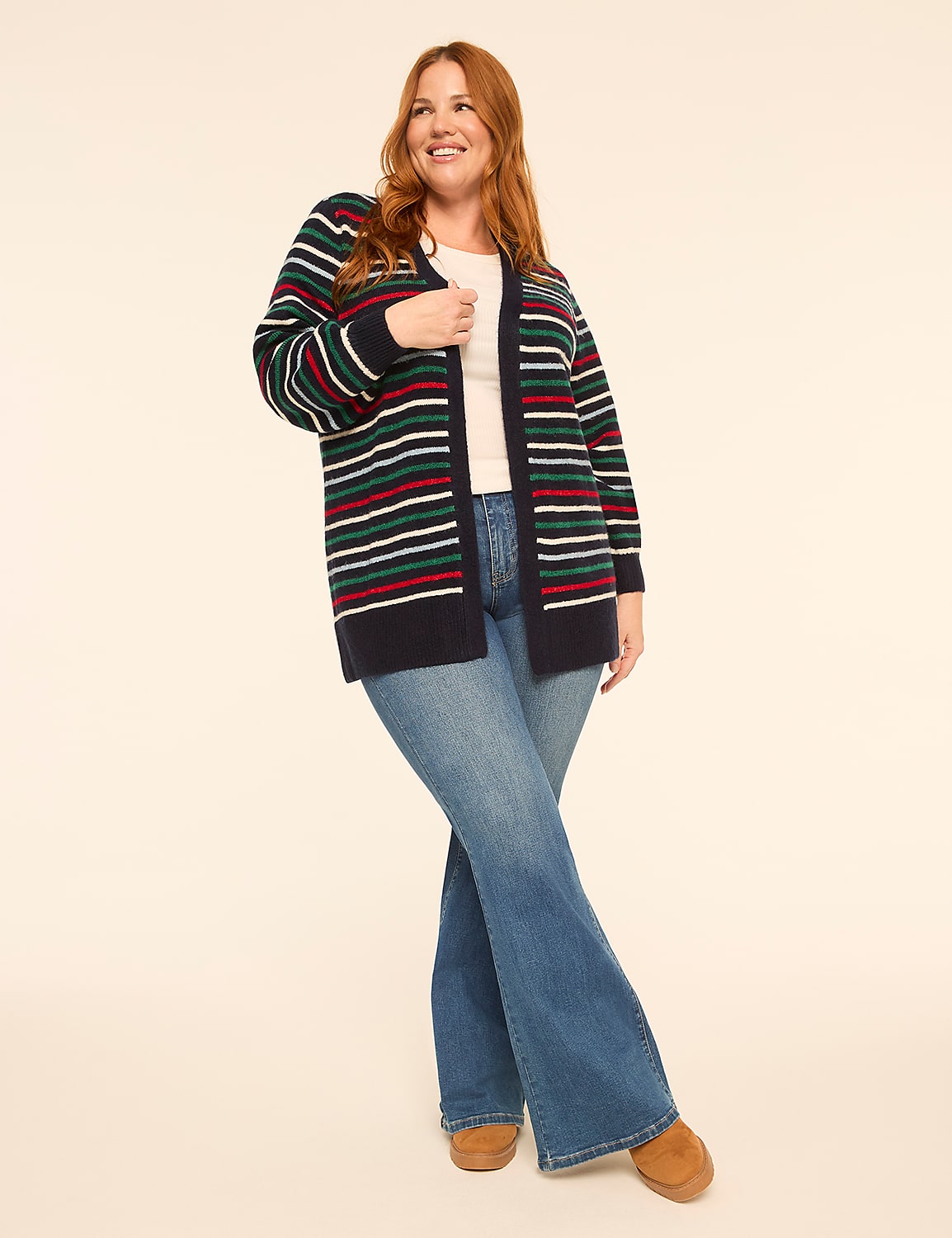 A smiling woman in a striped cardigan and flared jeans stands against a plain, light-colored background. Product Image 3