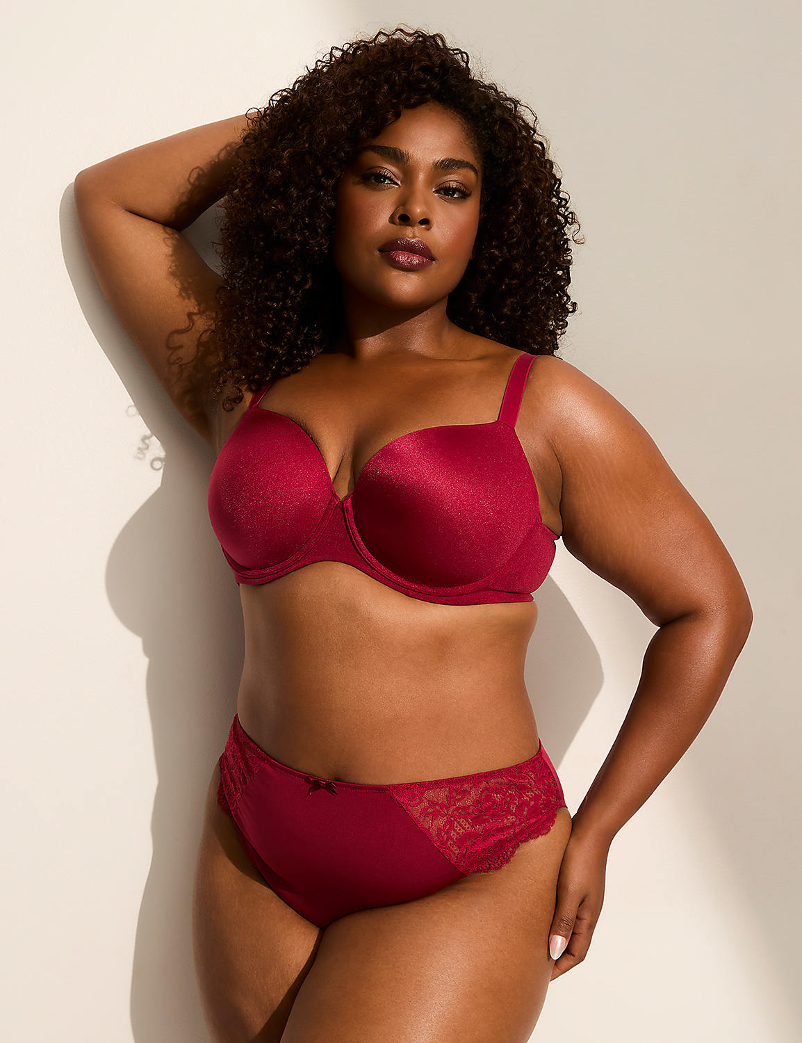 A woman in a red bra and panties poses against a plain, light-colored wall with soft shadows. Product Image 4