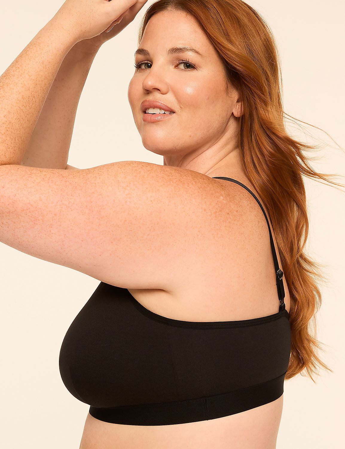 A woman with red hair and freckles in a black bra poses against a plain, light-colored background. Product Image 3