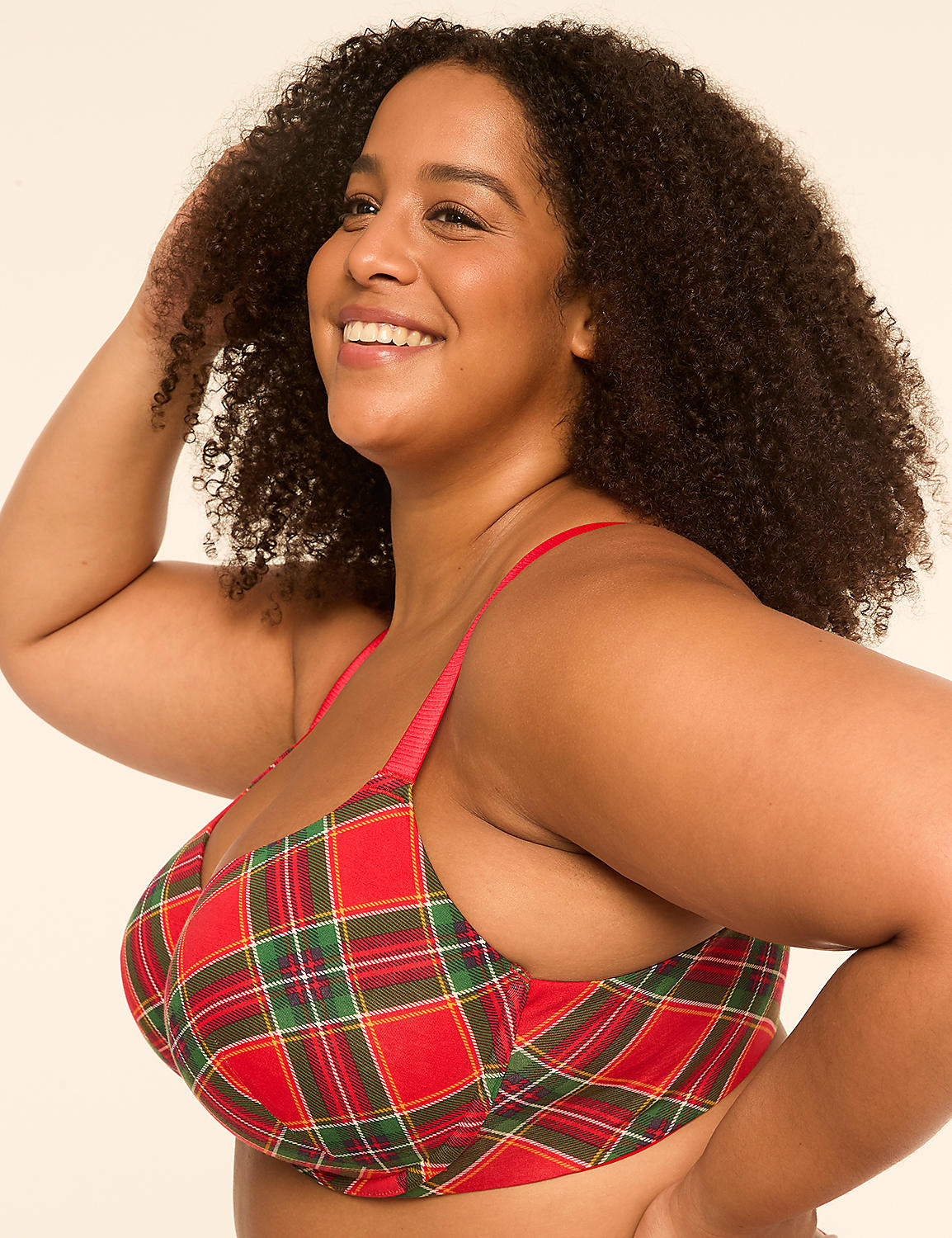 A smiling woman with curly hair poses in a red plaid bra against a plain, light-colored background. Product Image 3