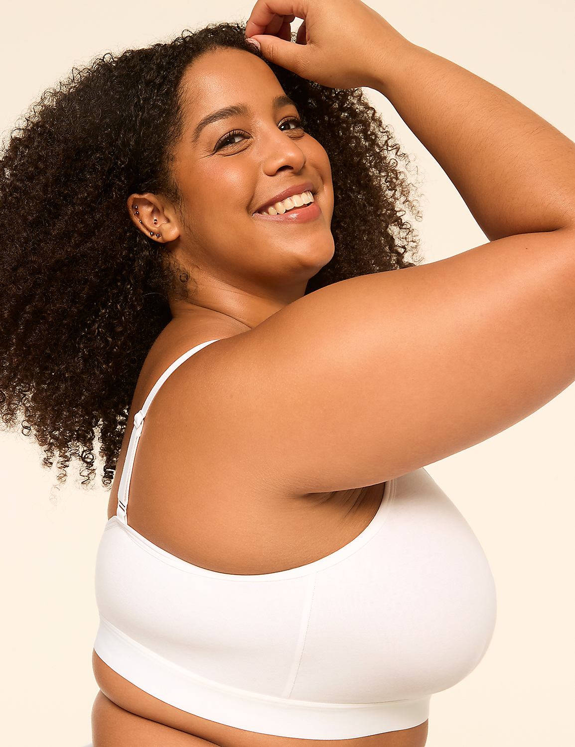 A smiling woman with curly hair in a white bra is posed against a plain, light-colored background. Product Image 3