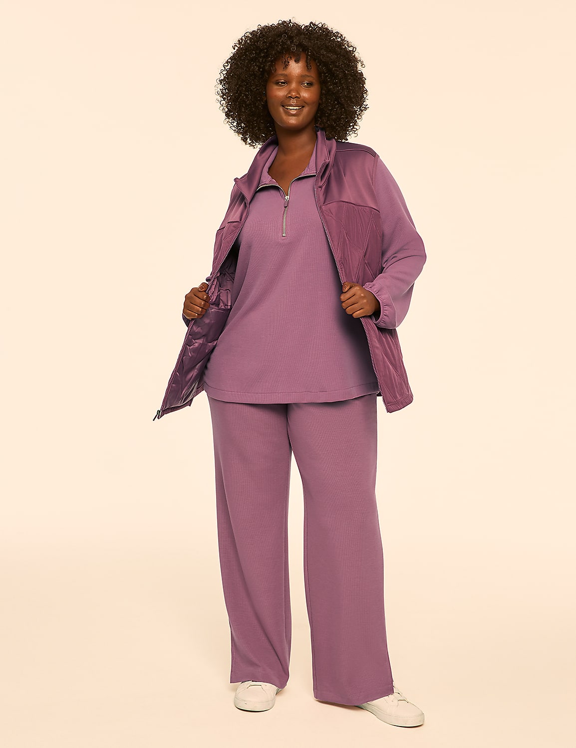 A smiling woman in a pink tracksuit stands against a plain, light-colored background. Product Image 3