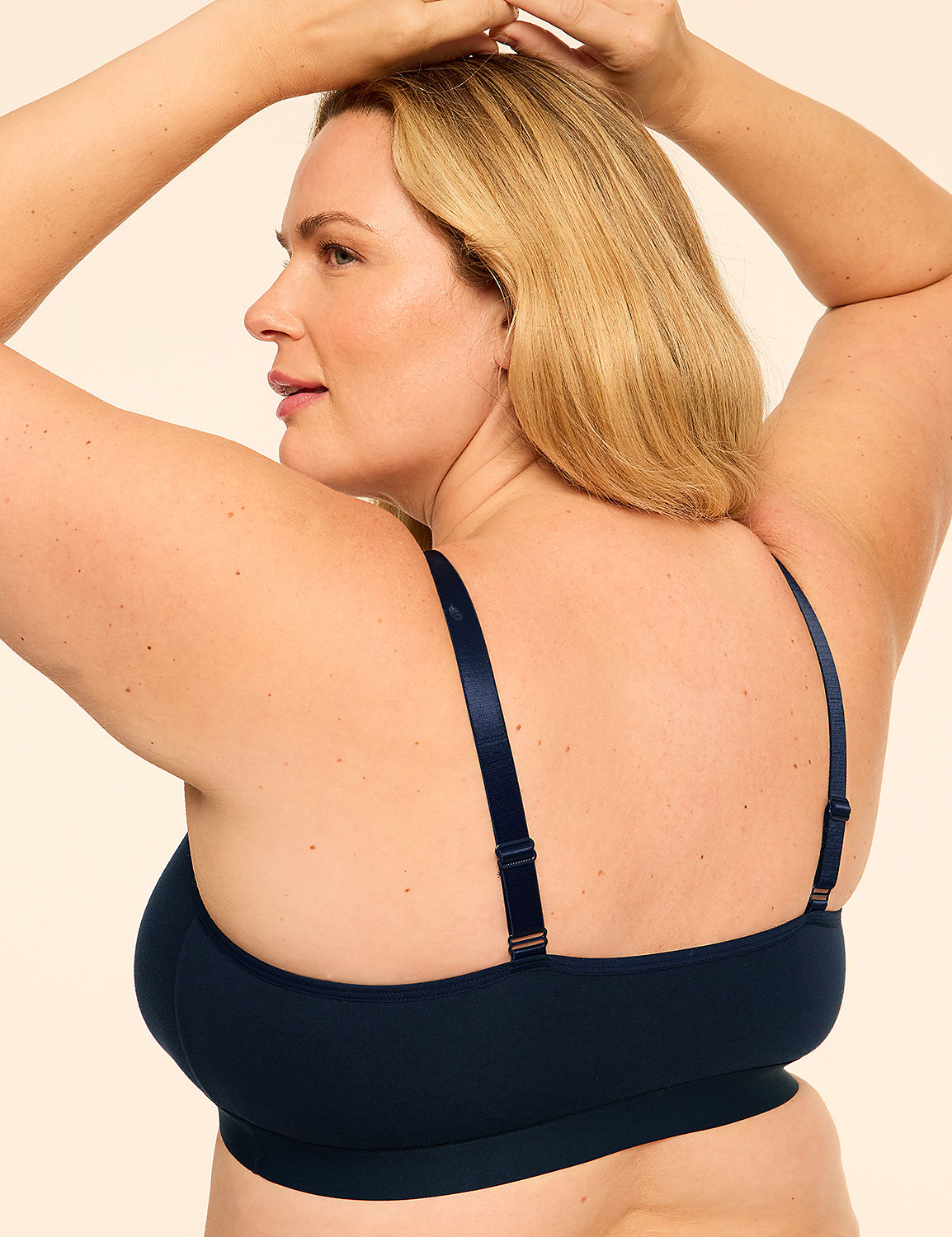A blonde woman wearing a navy blue bra poses with her arms raised against a plain, light-colored background. Product Image 2