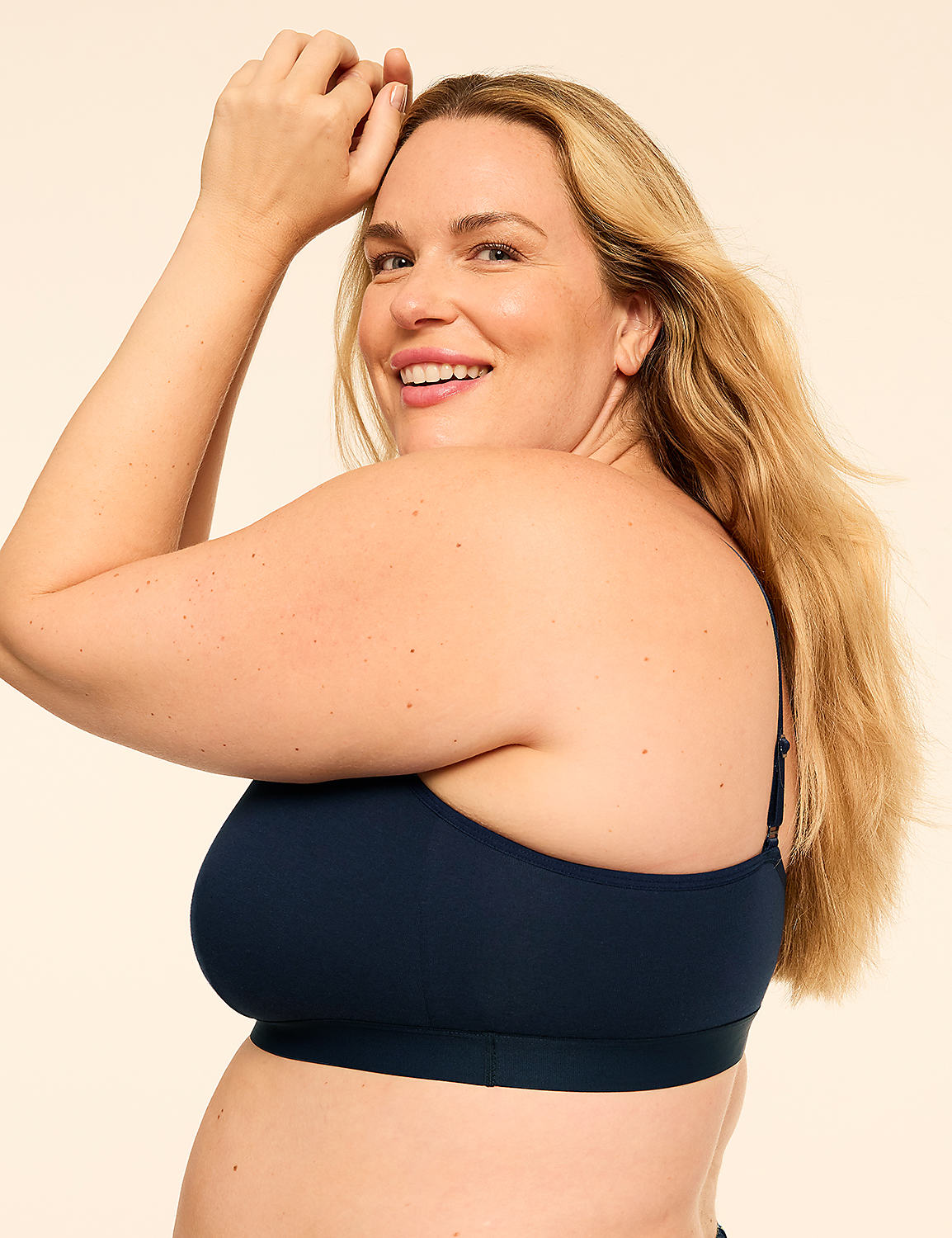A smiling woman with long blonde hair wearing a navy blue bra poses against a plain, light-colored background. Product Image 3