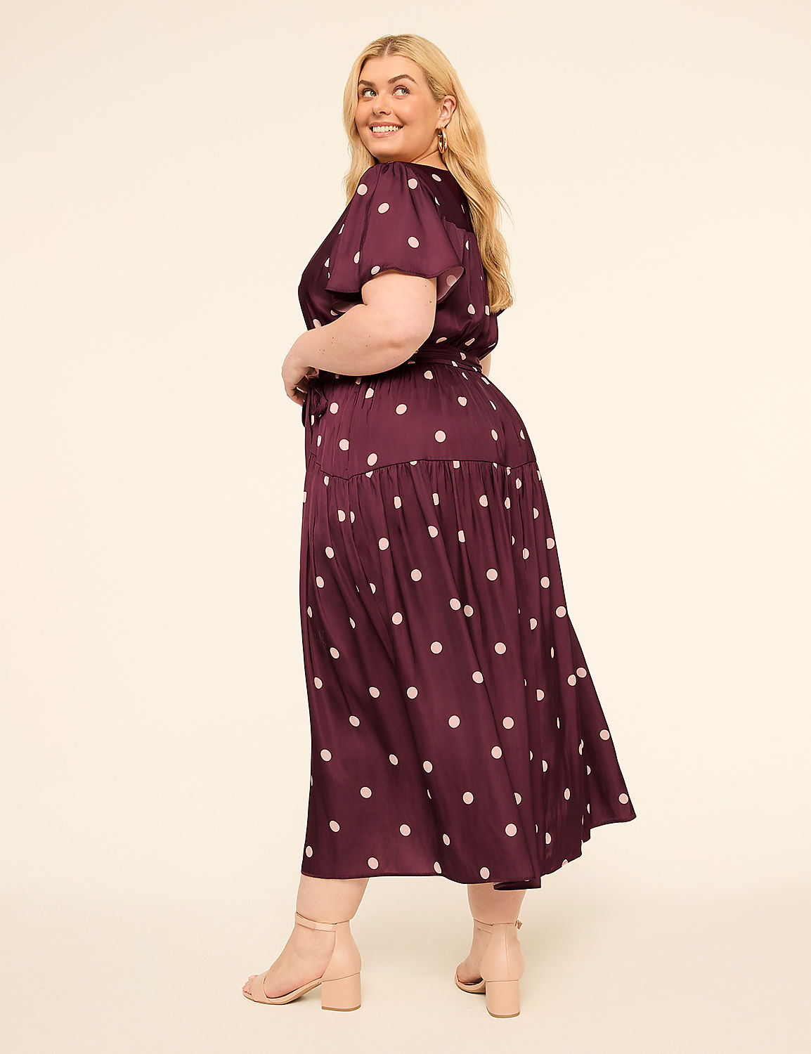 A woman in a polka-dot dress poses against a plain, light-colored background. Product Image 2