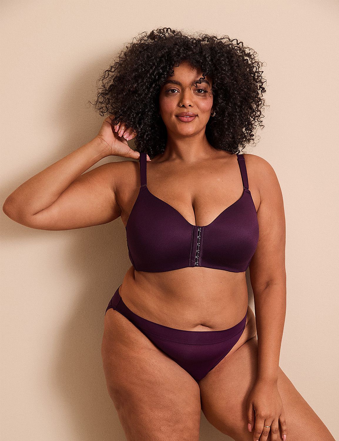 A woman with curly hair wearing a purple lingerie set poses against a plain, light-beige background. Product Image 6