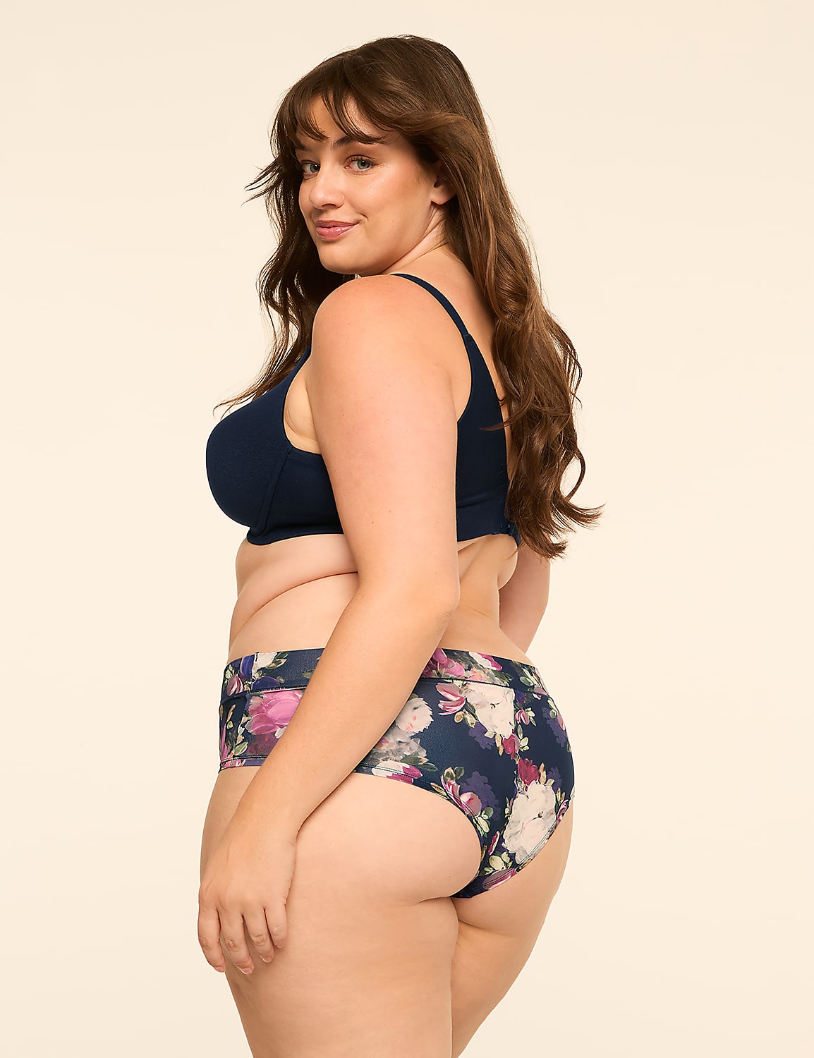 A woman wearing a navy blue bikini top and floral print bottoms poses against a plain, light-colored background. Product Image 2