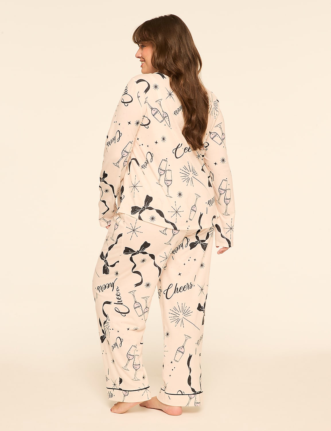 A woman wearing champagne-themed pajamas stands against a plain, light-colored background. Product Image 2