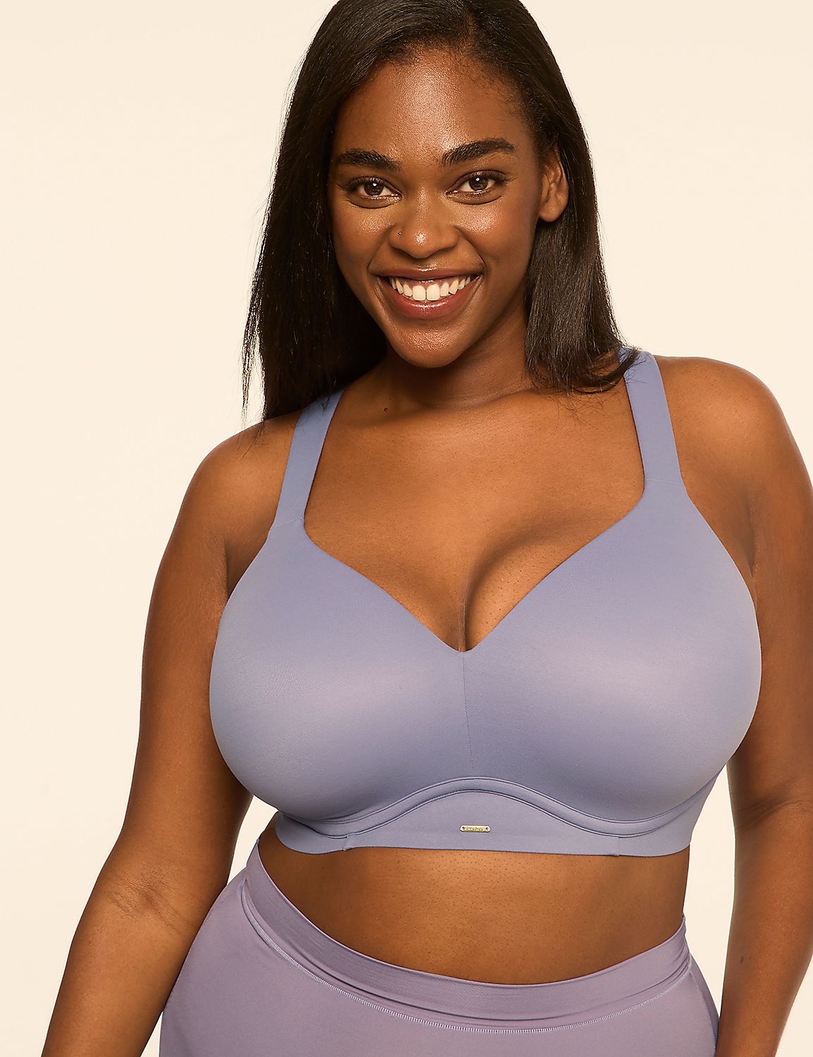 A smiling woman wearing a light purple bra and matching bottoms stands against a plain, light-colored background. Product Image 1