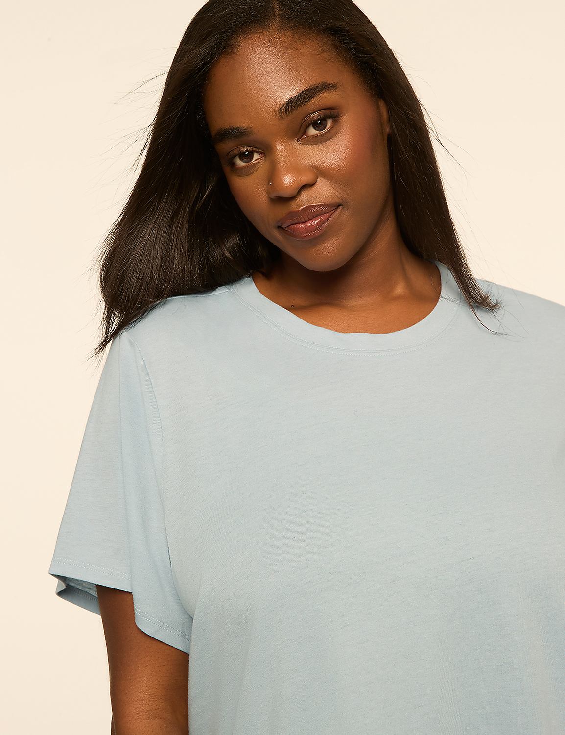 A woman with long dark hair wearing a light blue t-shirt poses against a plain, neutral background. Product Image 4