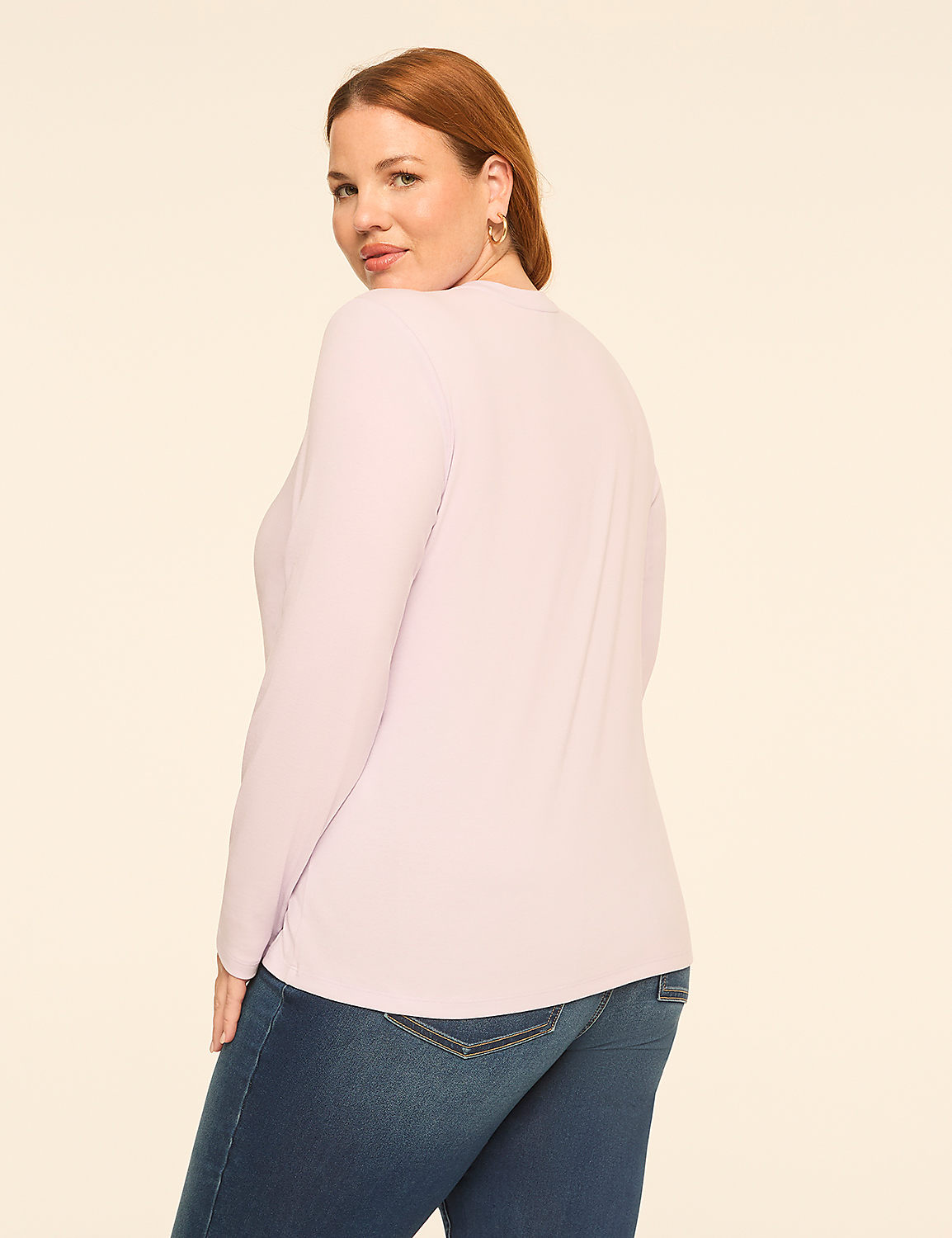A woman wearing a light purple long-sleeved shirt and blue jeans stands against a plain, off-white background. Product Image 2