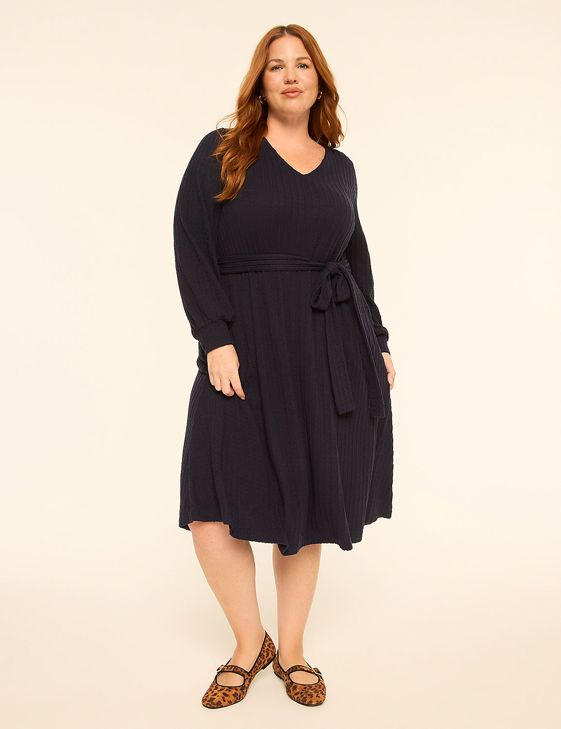 A woman wearing a navy blue dress and leopard print flats stands against a plain, light-colored background. Product Image 1