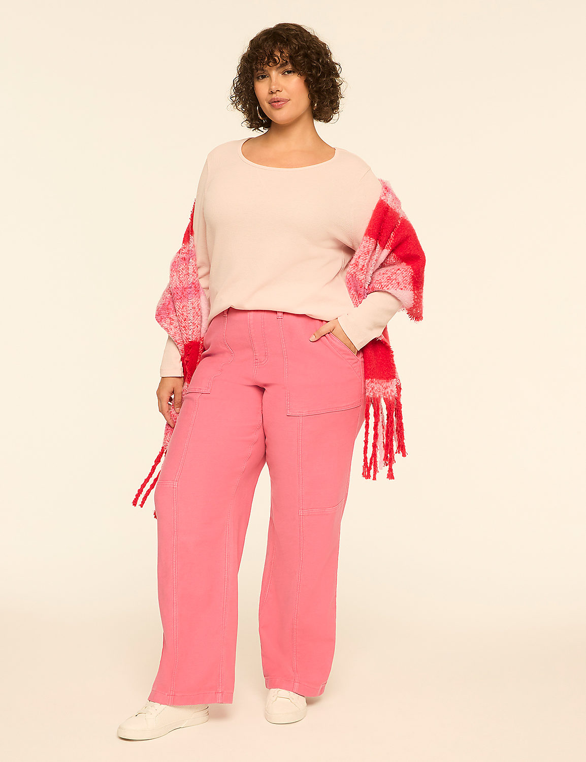 A woman wearing a light pink sweater, bright pink pants, and a red and pink checkered shawl stands against a plain off-white background. Product Image 3