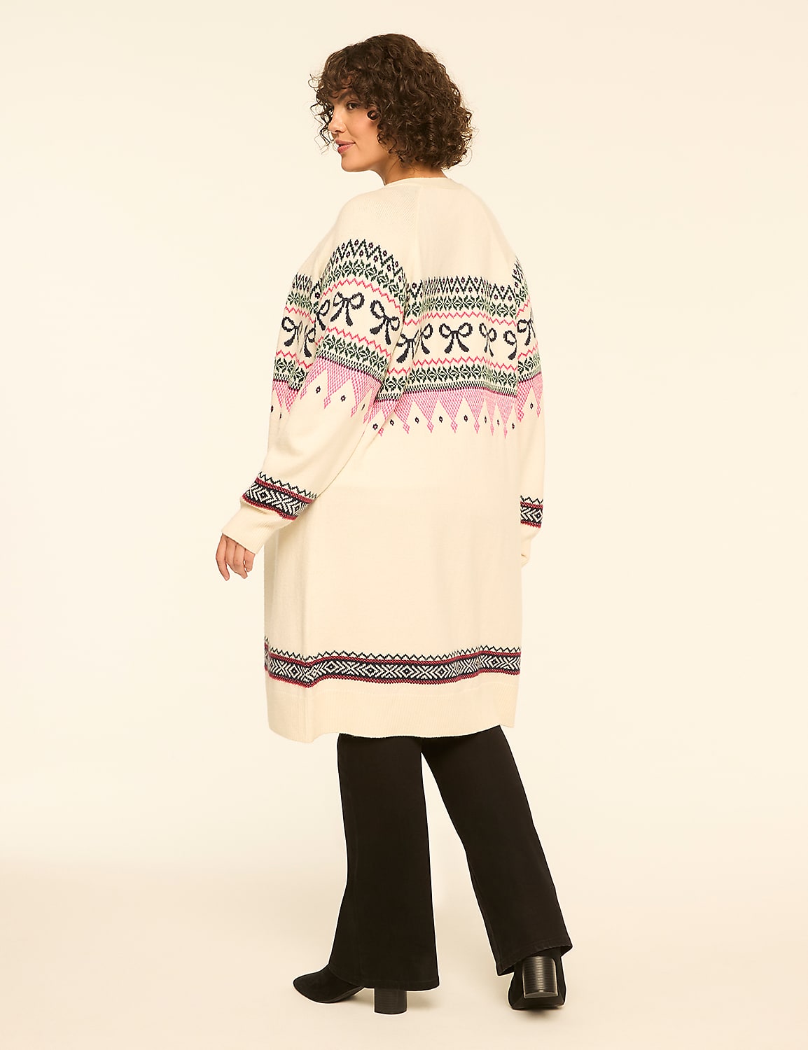 A woman wearing a long, patterned cream cardigan and black trousers stands against a plain white background. Product Image 2