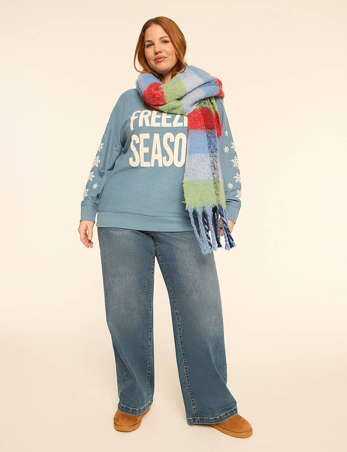 A woman wearing a blue sweatshirt, wide-leg jeans, and a colorful scarf stands against a plain white background. Product Image 3
